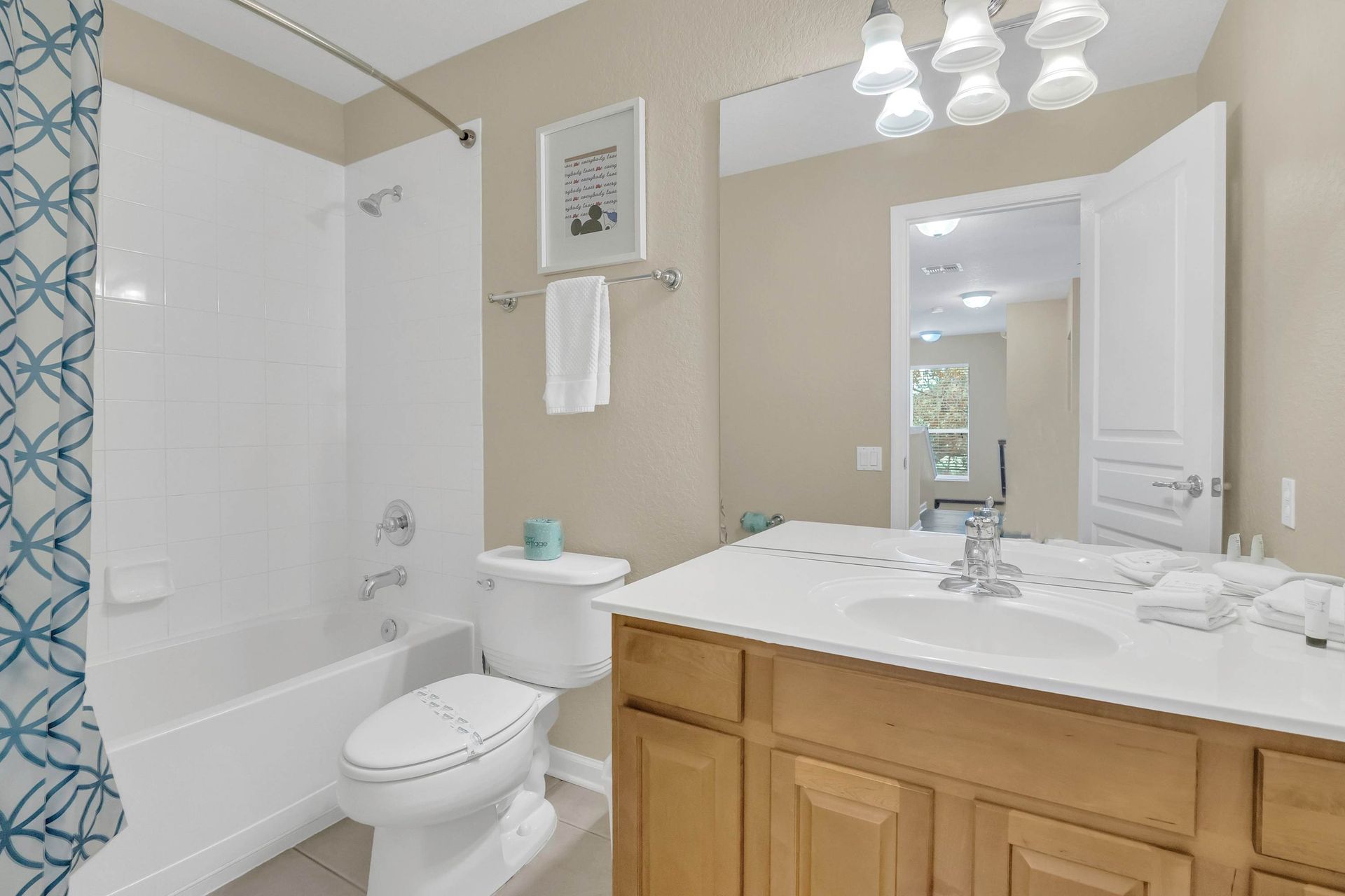 Bright, well-lit bathroom featuring a large vanity and tub.