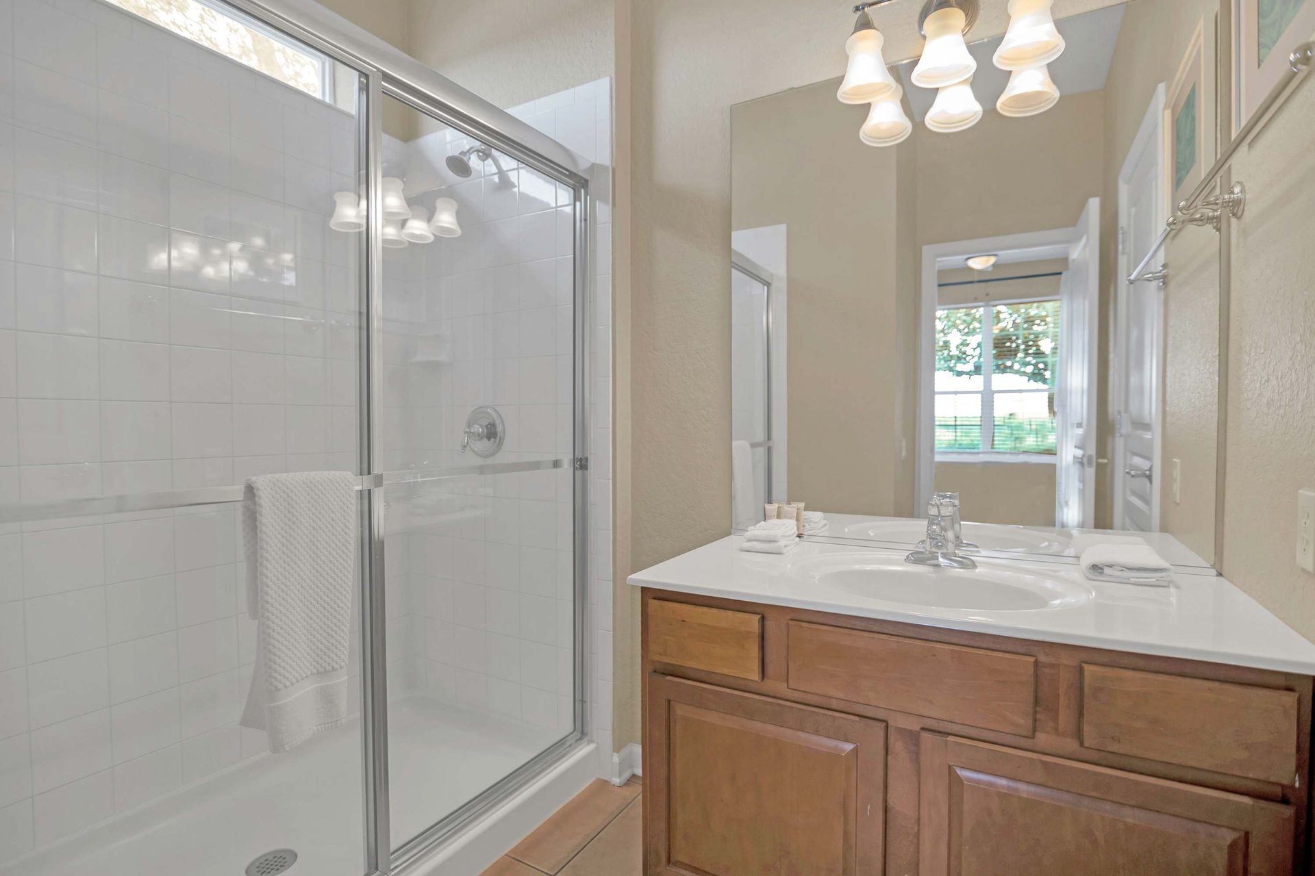 Walk-in glass shower and single vanity in a clean, bright bathroom.