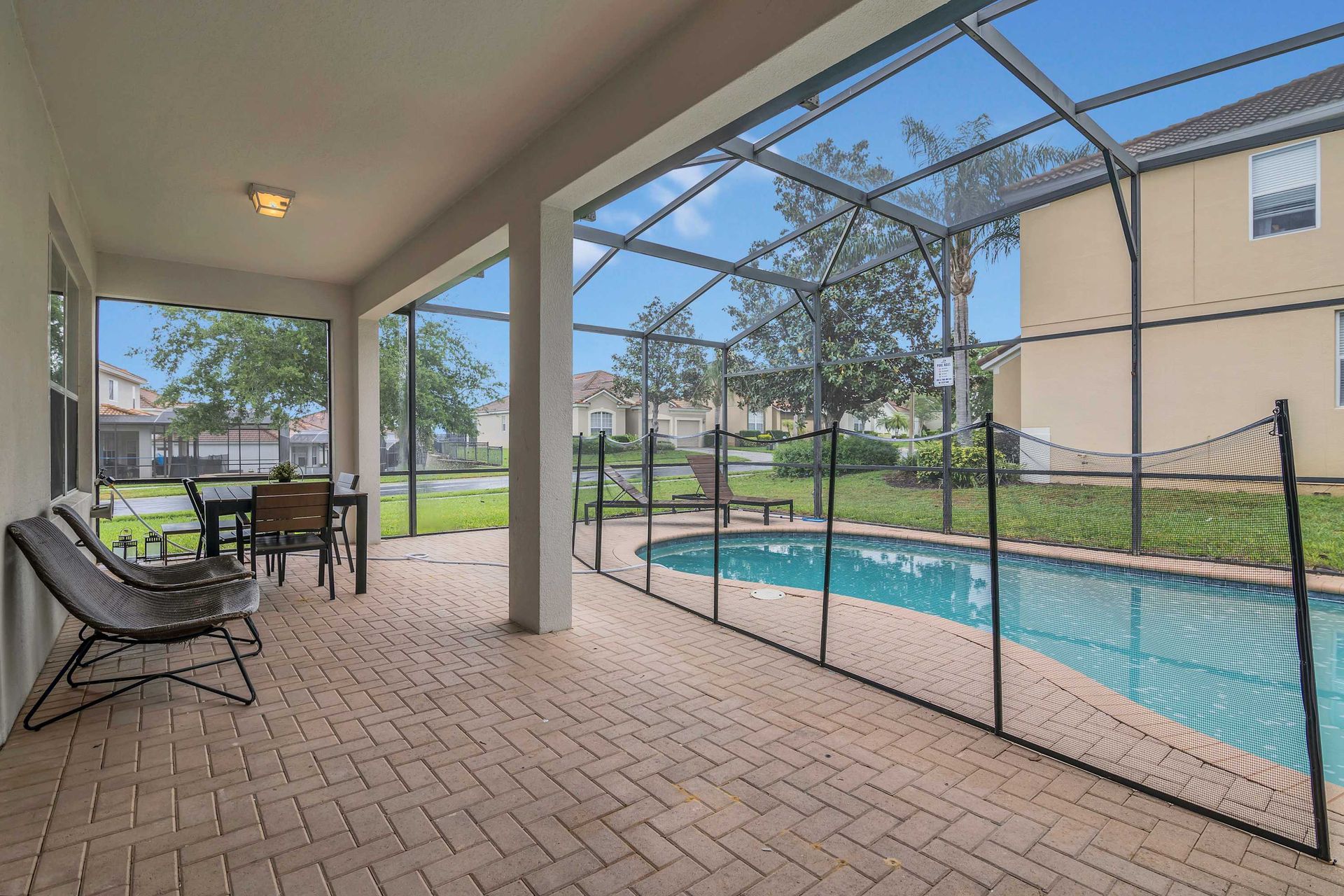 Covered patio lounge/dining next to a private, fenced pool area. 