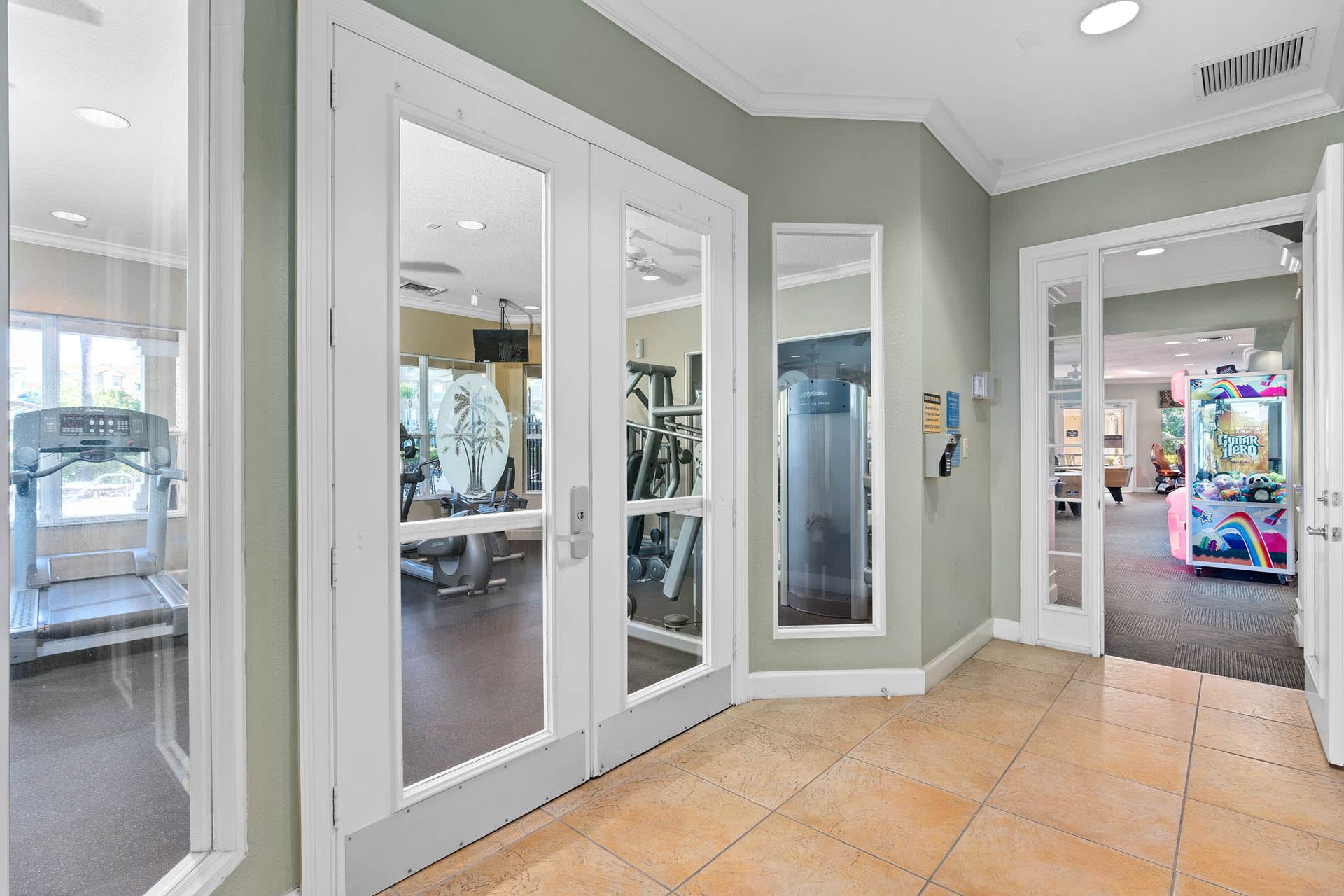 Fitness center and arcade access from a bright, modern hallway.