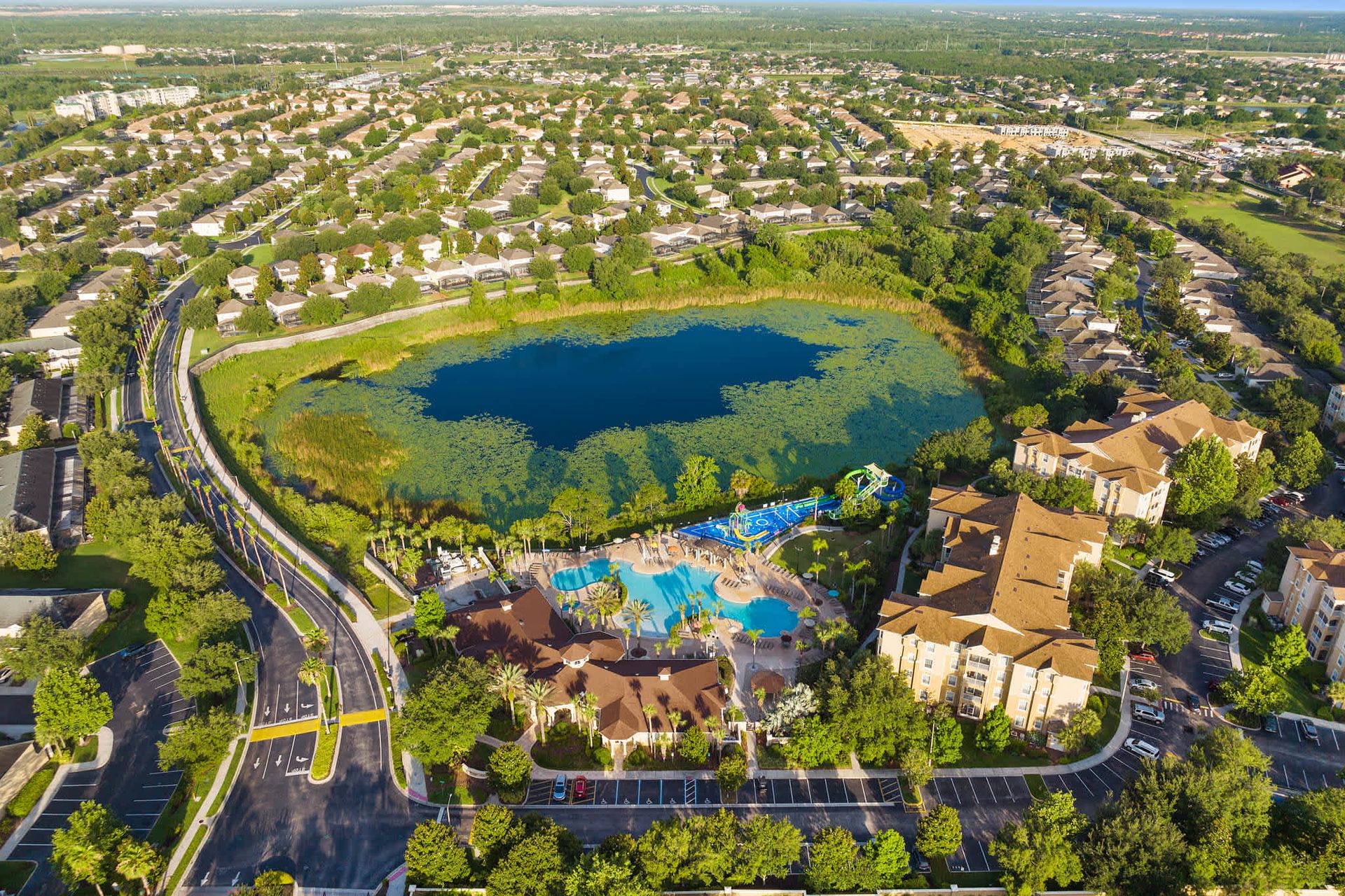 Water park and pool area nestled beside a serene, central lake.
