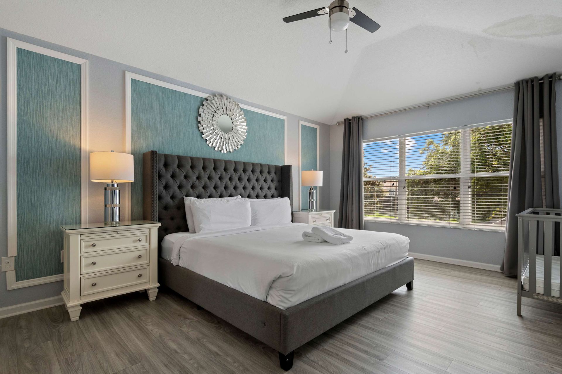 Spacious master suite with king bed, elegant accents, and a private crib area
