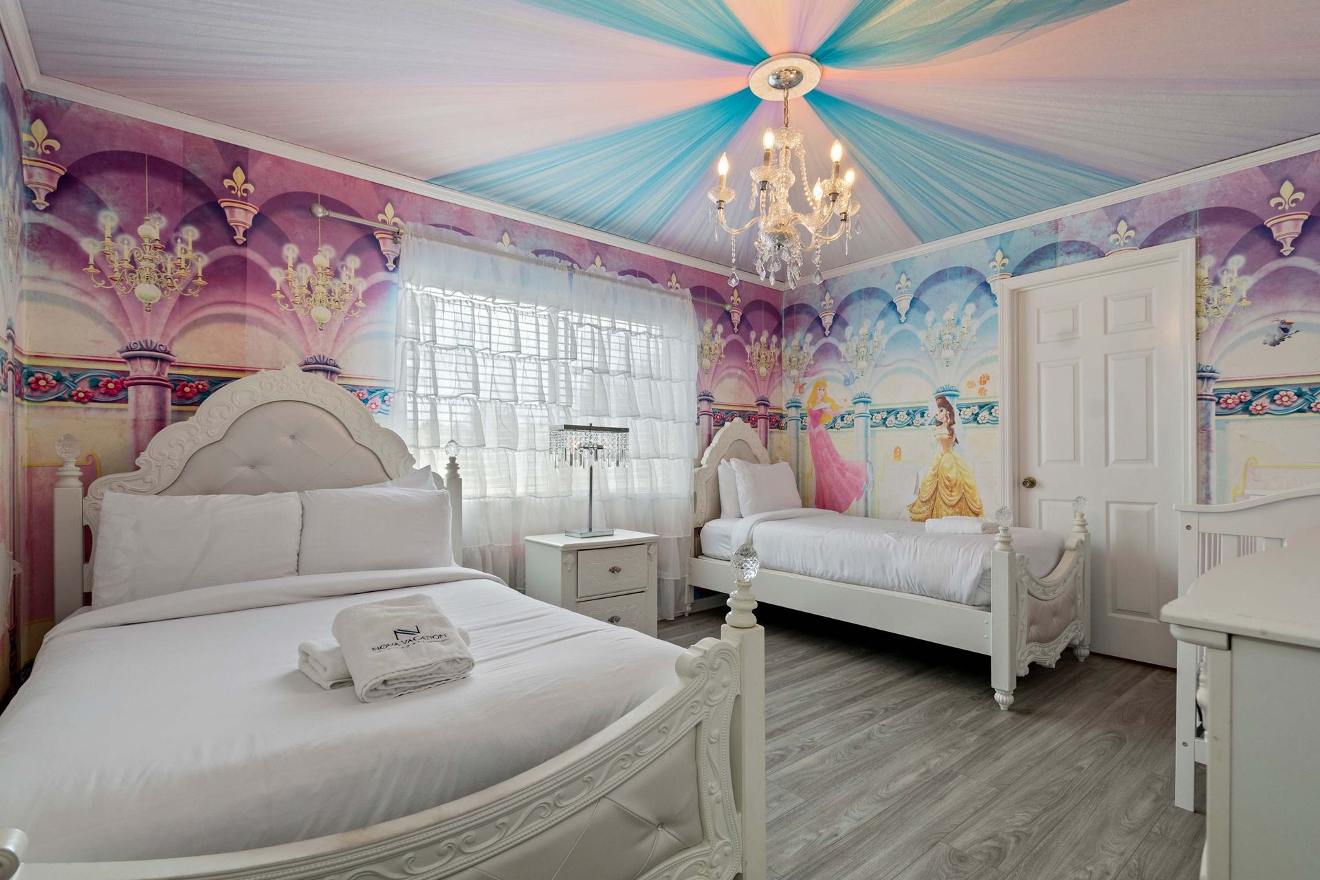 Enchanting princess-themed room with chandelier, dreamy murals, and royal beds
