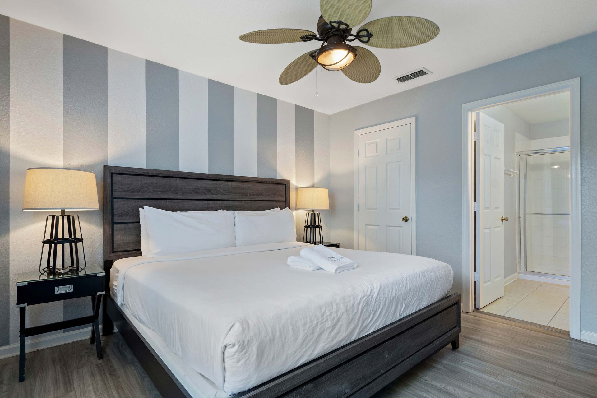 Stylish king bedroom with ensuite bath, modern decor, and relaxing neutral tones
