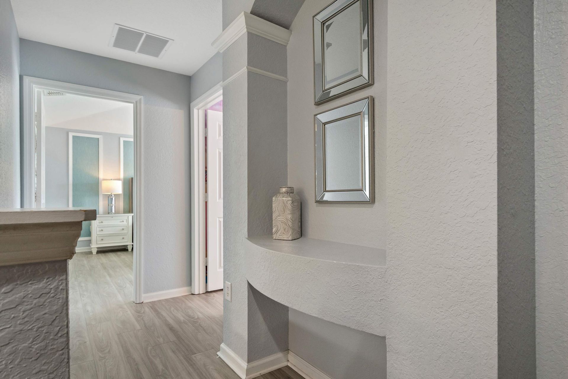 Stylish hallway nook with modern decor, textured walls, and elegant mirror accents
