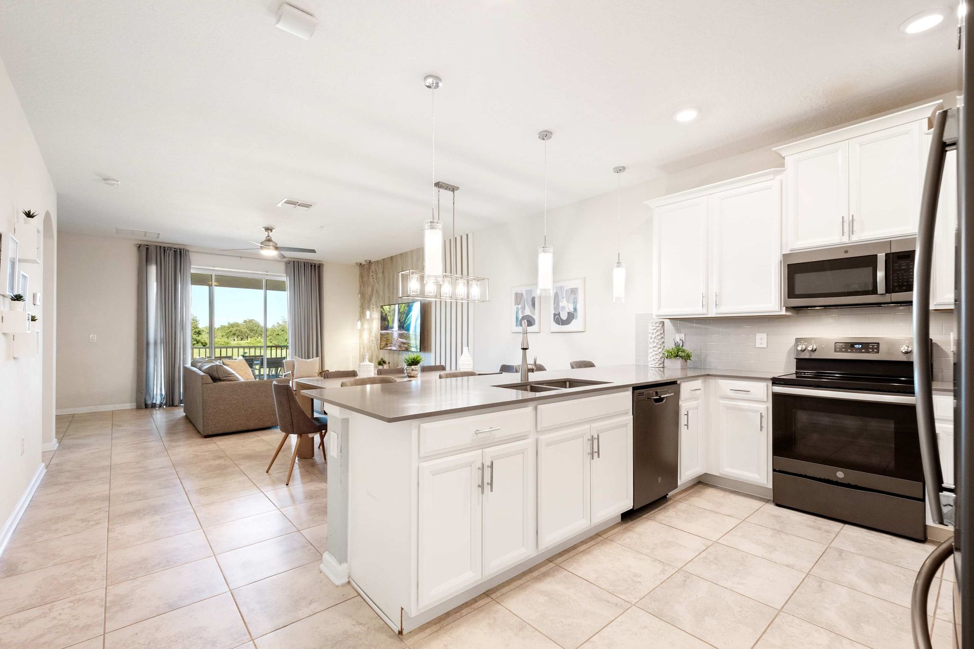 Spacious white kitchen with dark appliances and a large center island.