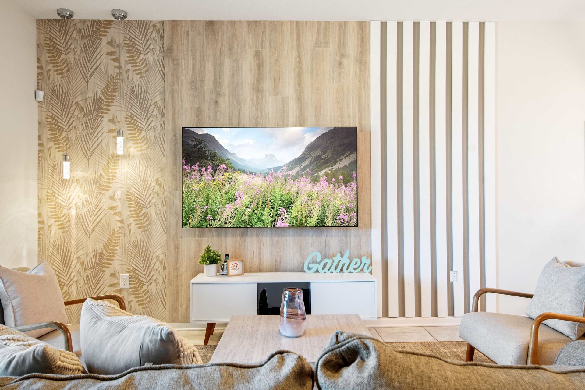Custom TV wall: mixed wood panels, striped wallpaper, and chic lighting.