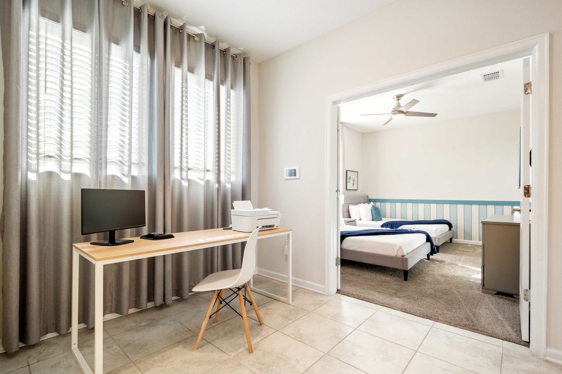 Dedicated workspace with printer and natural light near the twin bedroom.