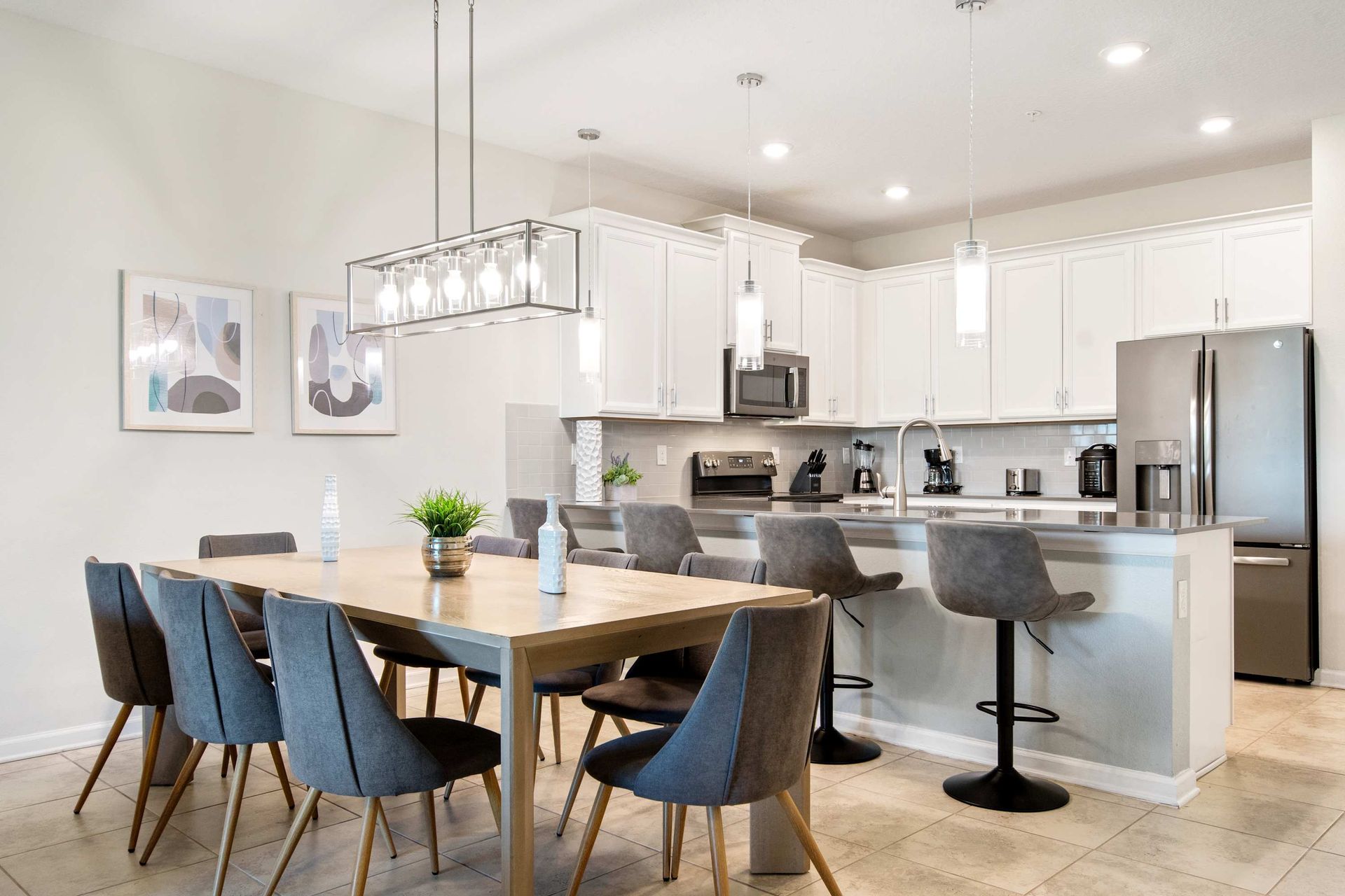 Clean white kitchen, gray accents, and modern lighting define the space.
