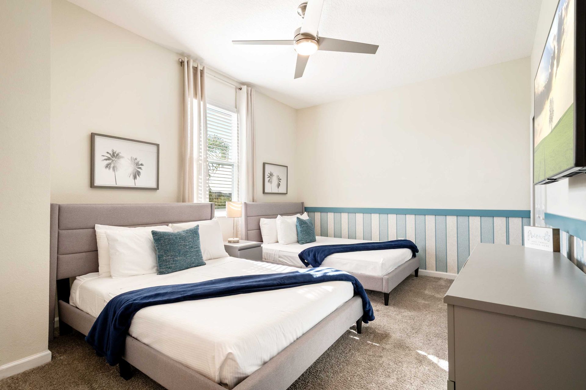 Two comfy full beds with plush headboards and nautical blue accents.