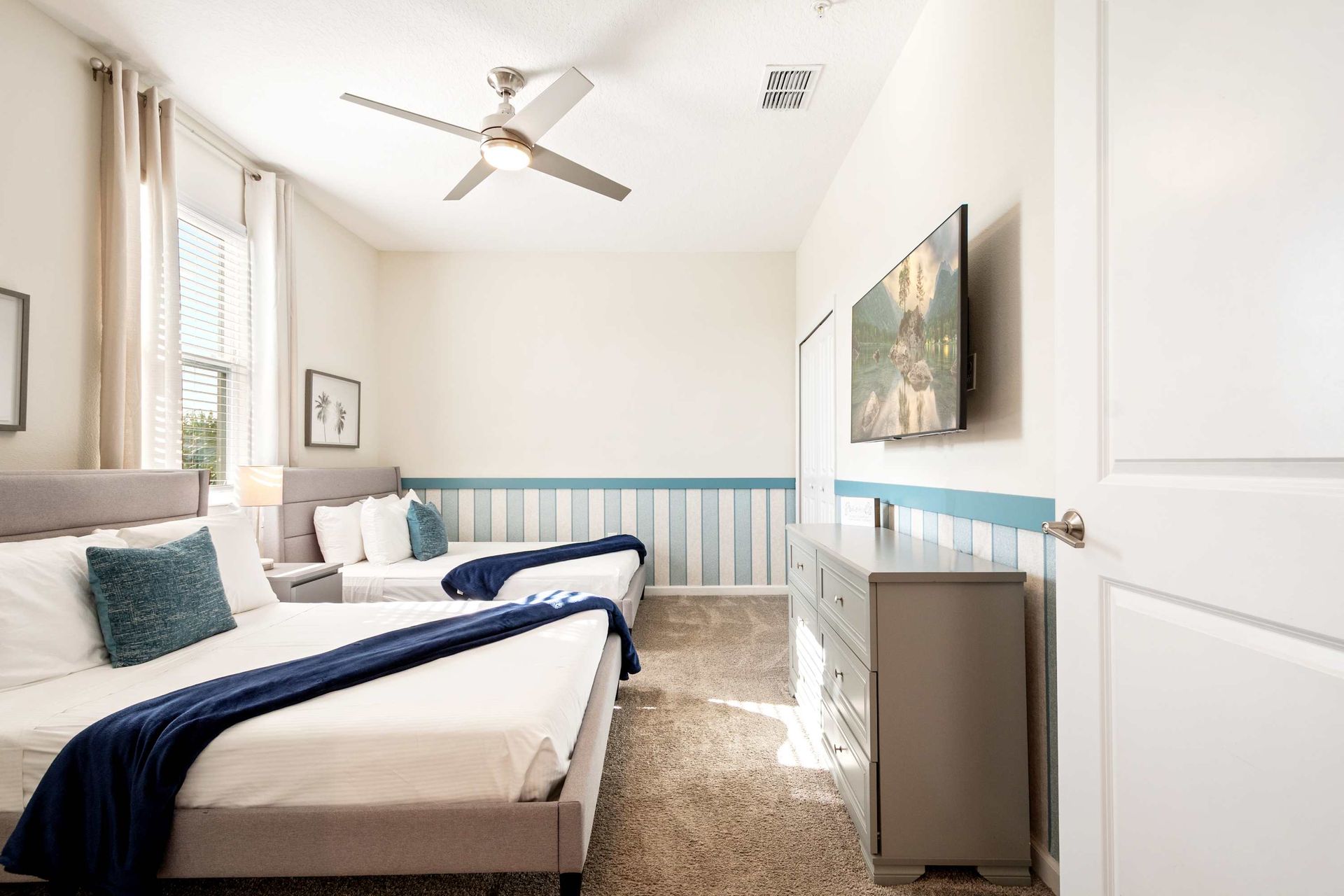 Two comfy full beds, large TV, and ceiling fan for a relaxed stay.