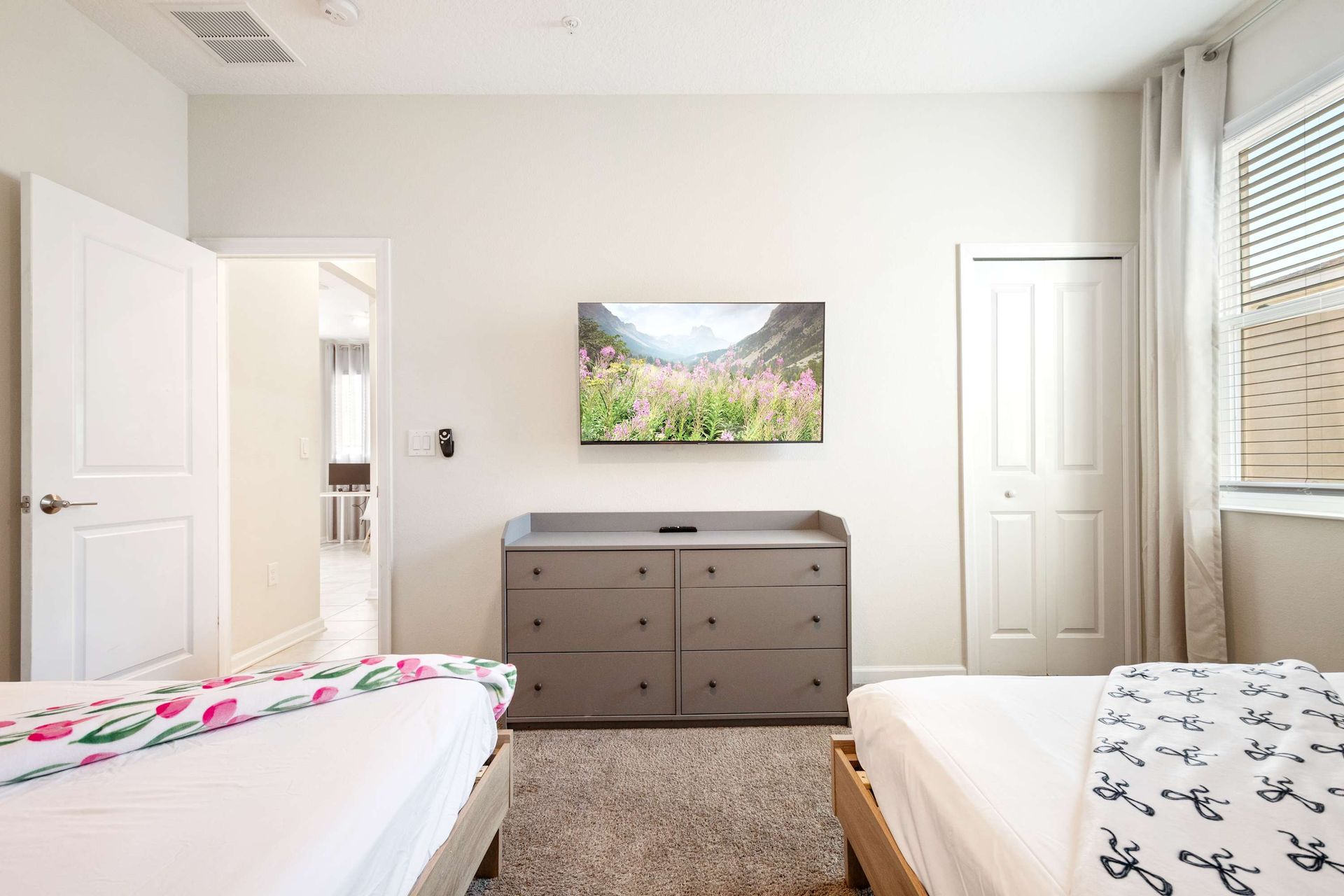 Two comfy Queen beds, large TV, and spacious dresser for storage.