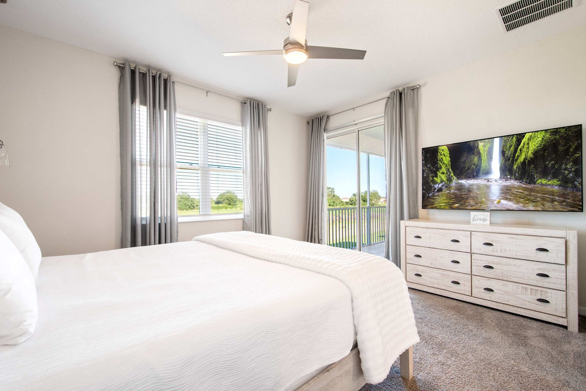 Luxurious King suite with huge TV, balcony access, and ample storage.