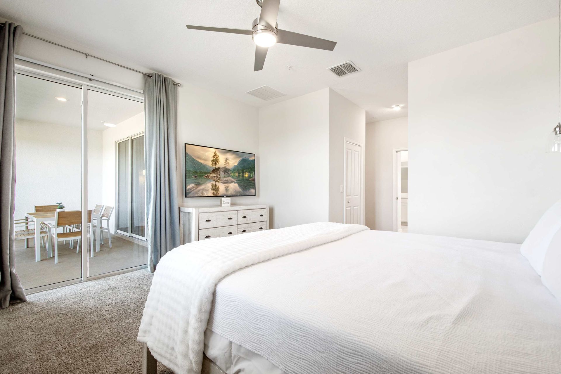 Plush King suite with patio access and ceiling fan for comfort.