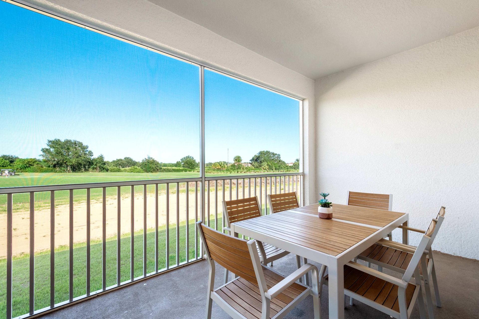 Dining with a view! Screened balcony overlooks the vast green fields.