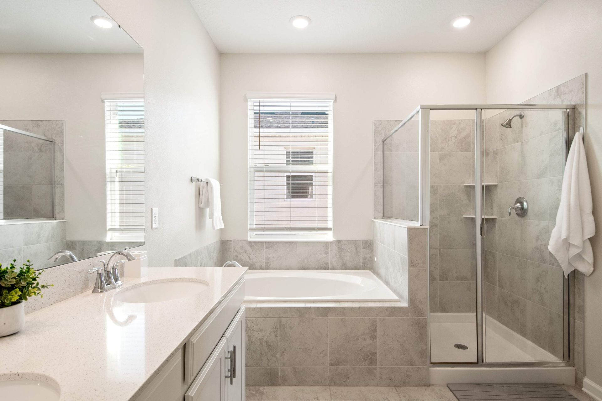 Master spa bath with soaking tub, glass shower, and dual vanity.