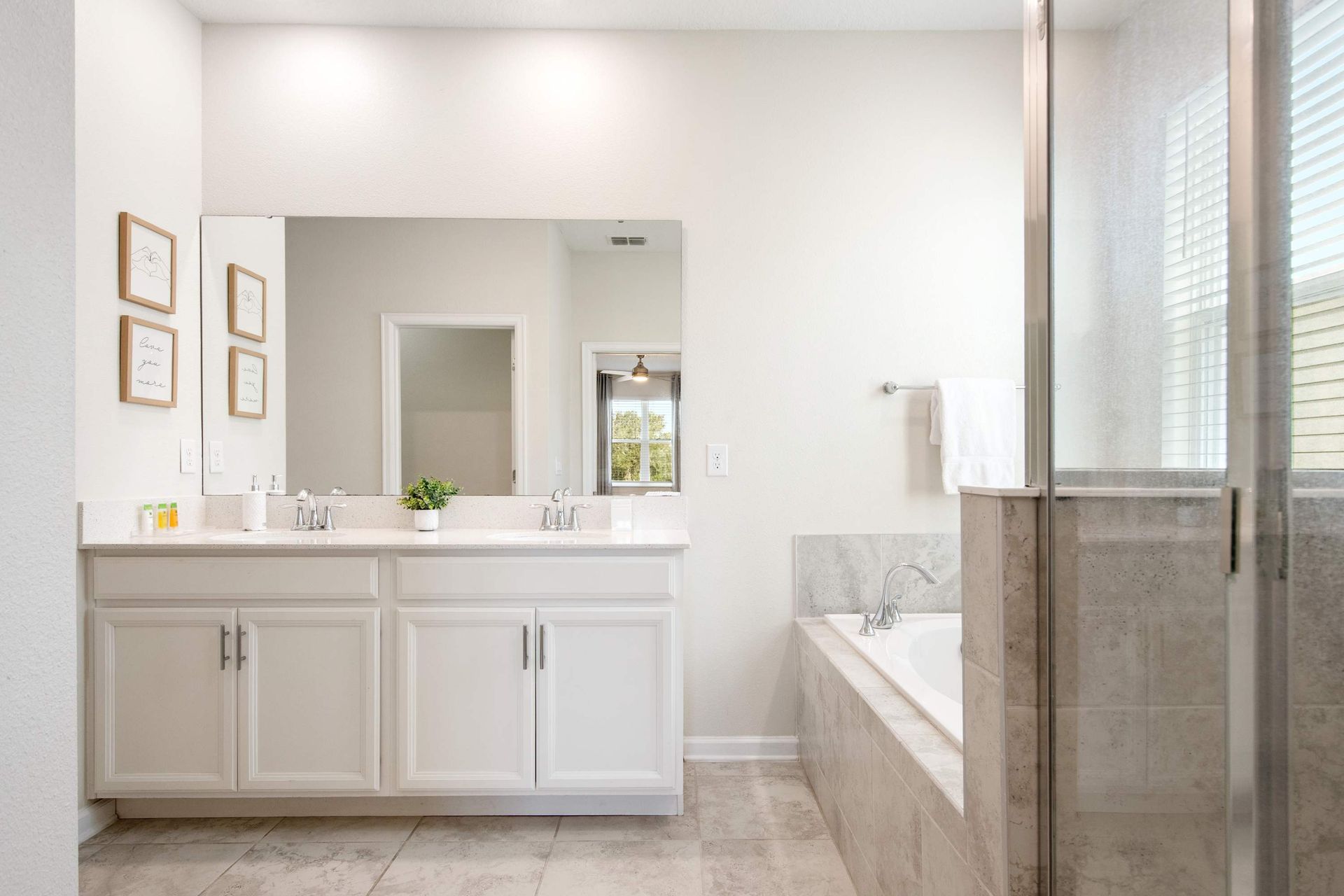 Bright, modern design with a huge mirror and clean white cabinets.