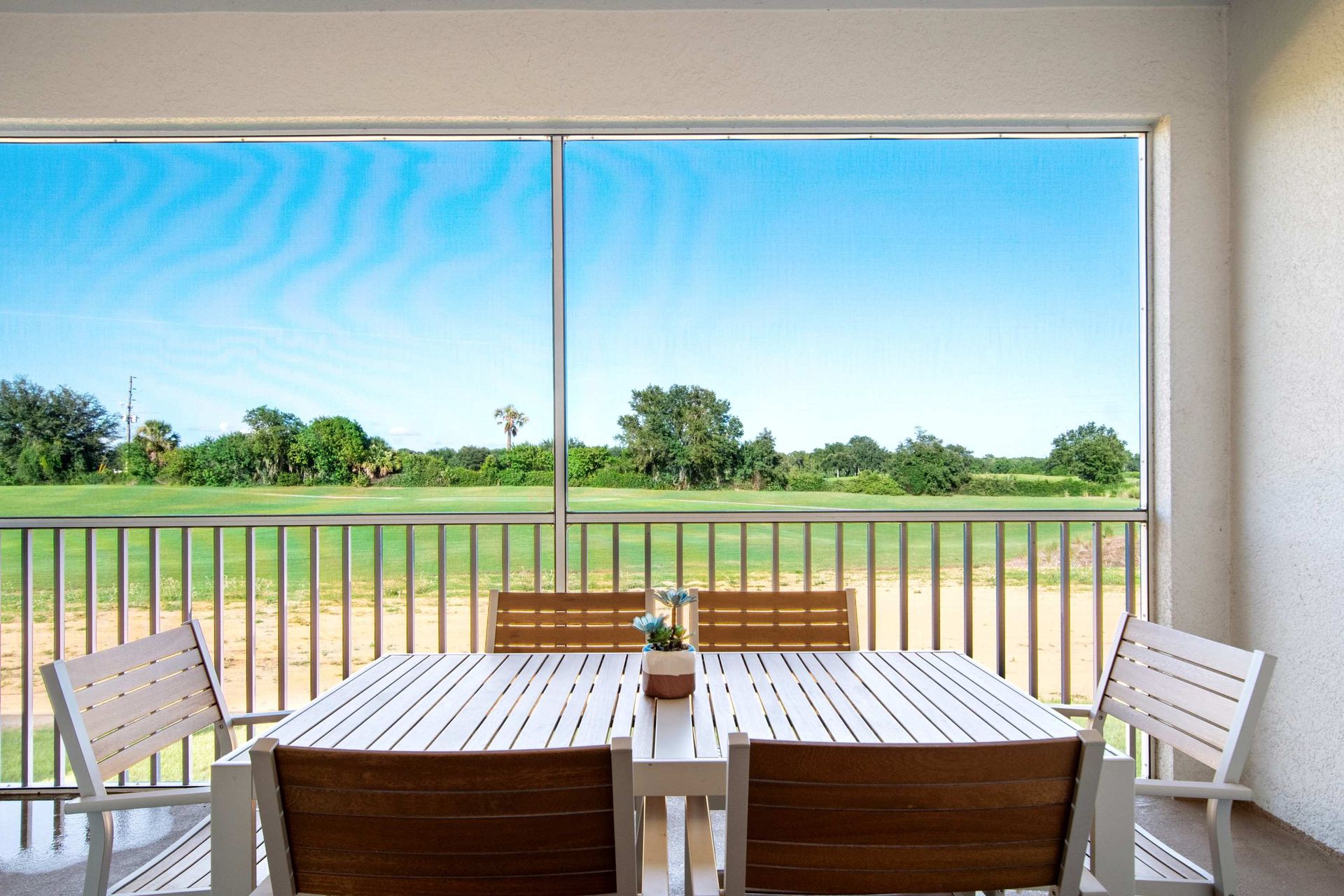 Al fresco dining on a screened patio with a serene, sunny view.