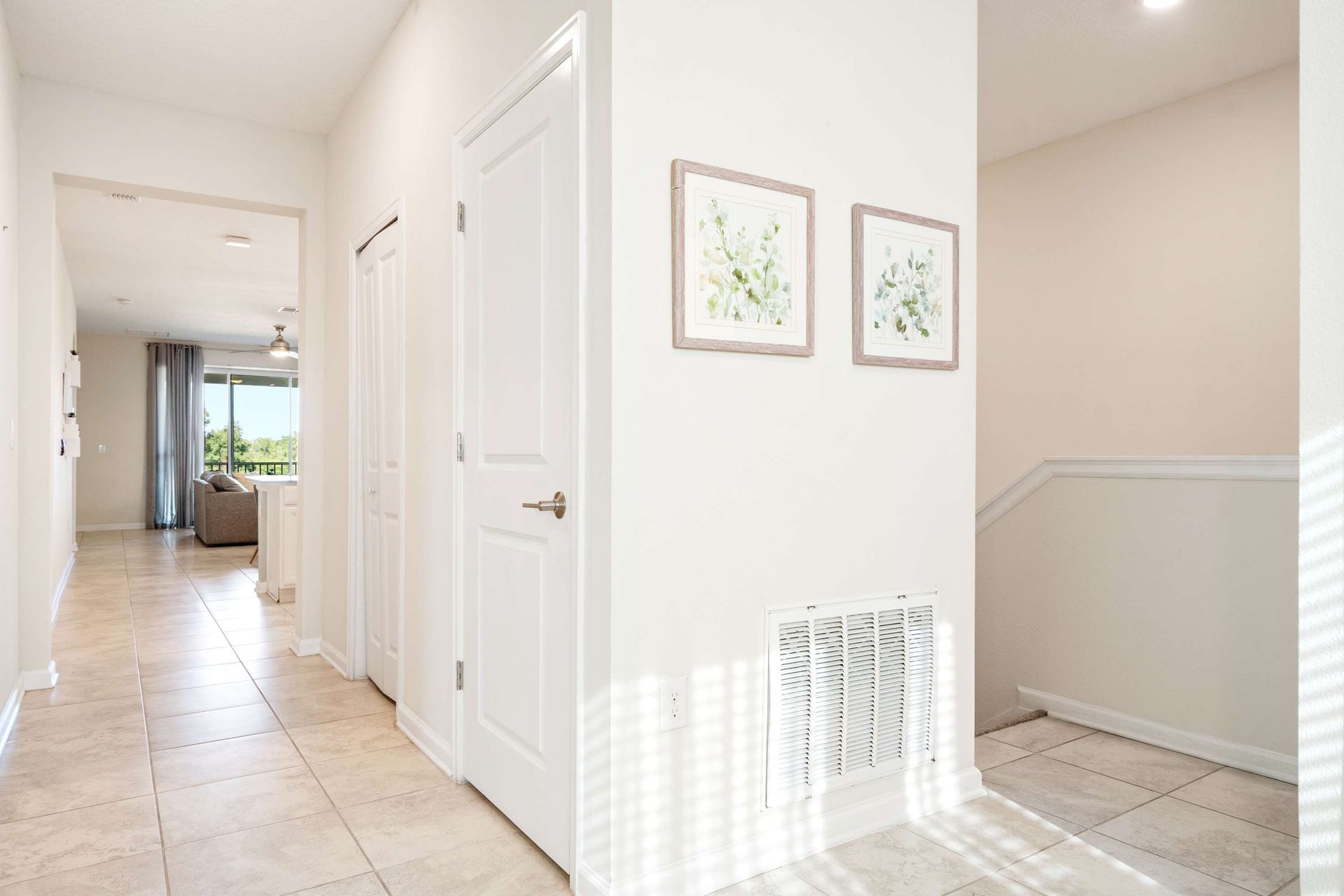 Bright tiled hallway leads past storage and into the sunny living area.