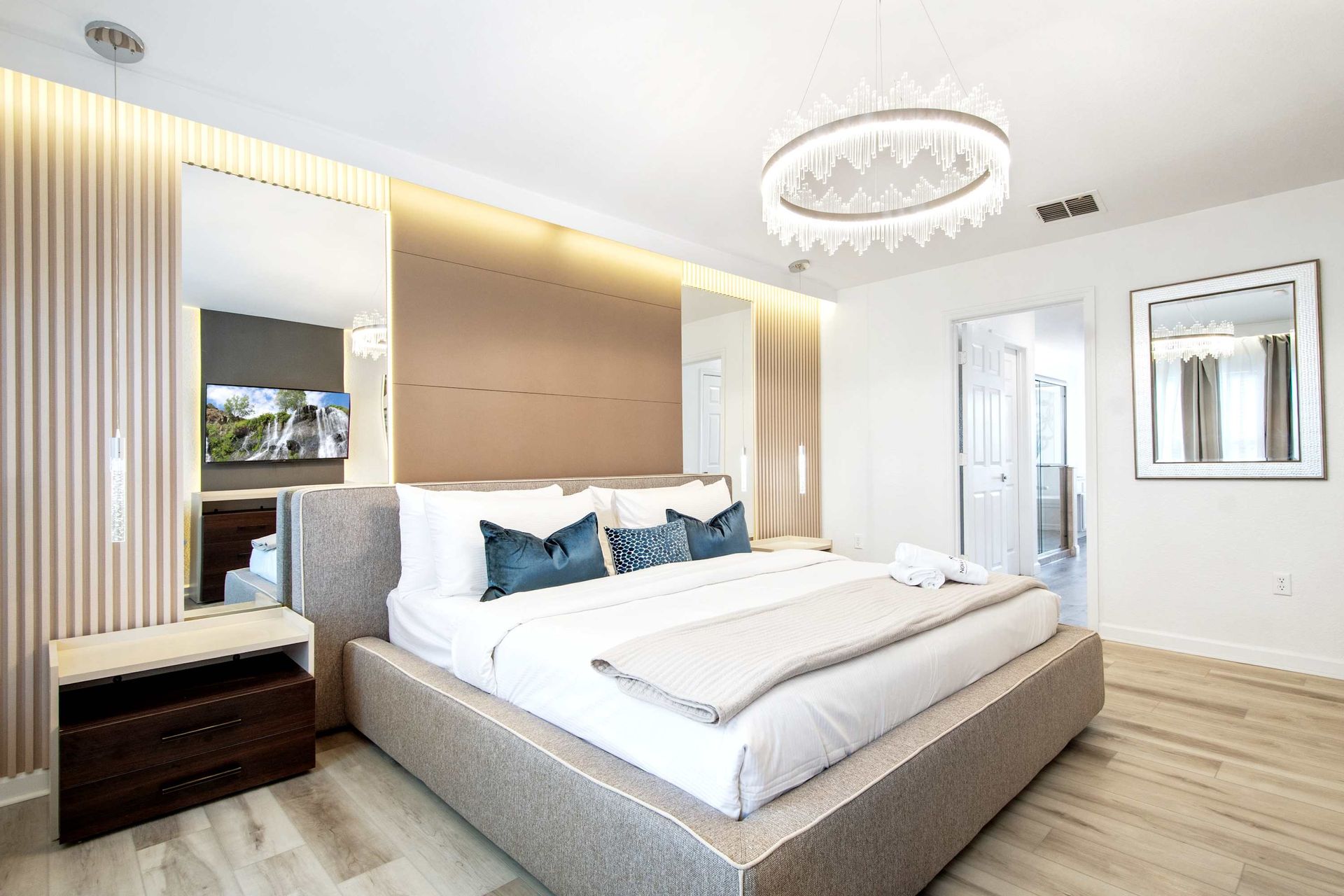 Luxurious King suite with mirrored accents, custom lighting, and chic decor.