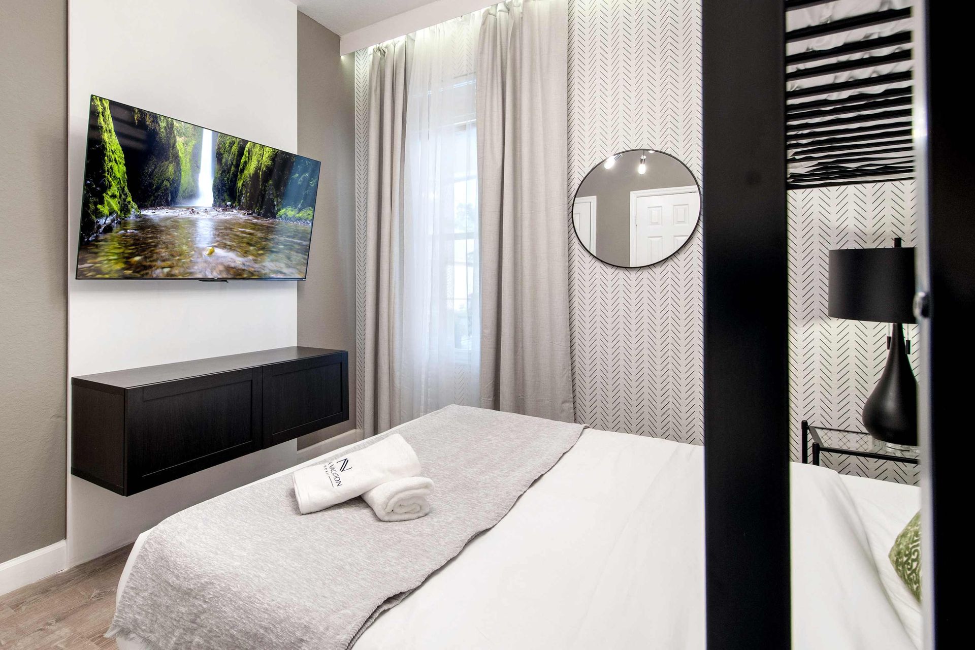 Cozy queen bed, large TV, and chic black and white design. 