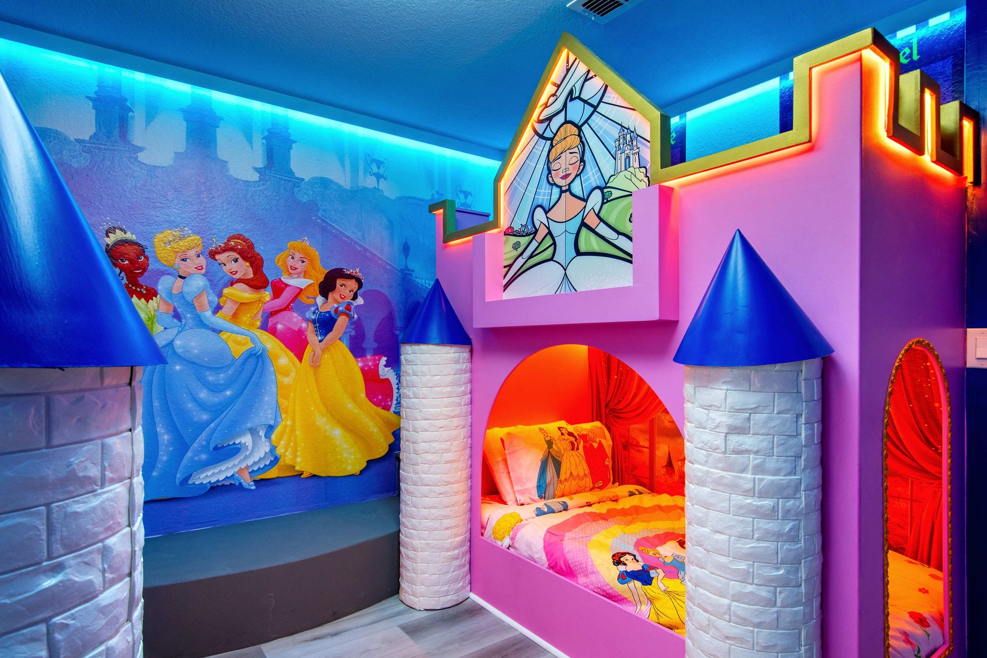 A royal dream! Pink castle bunk bed and princess mural with neon light.