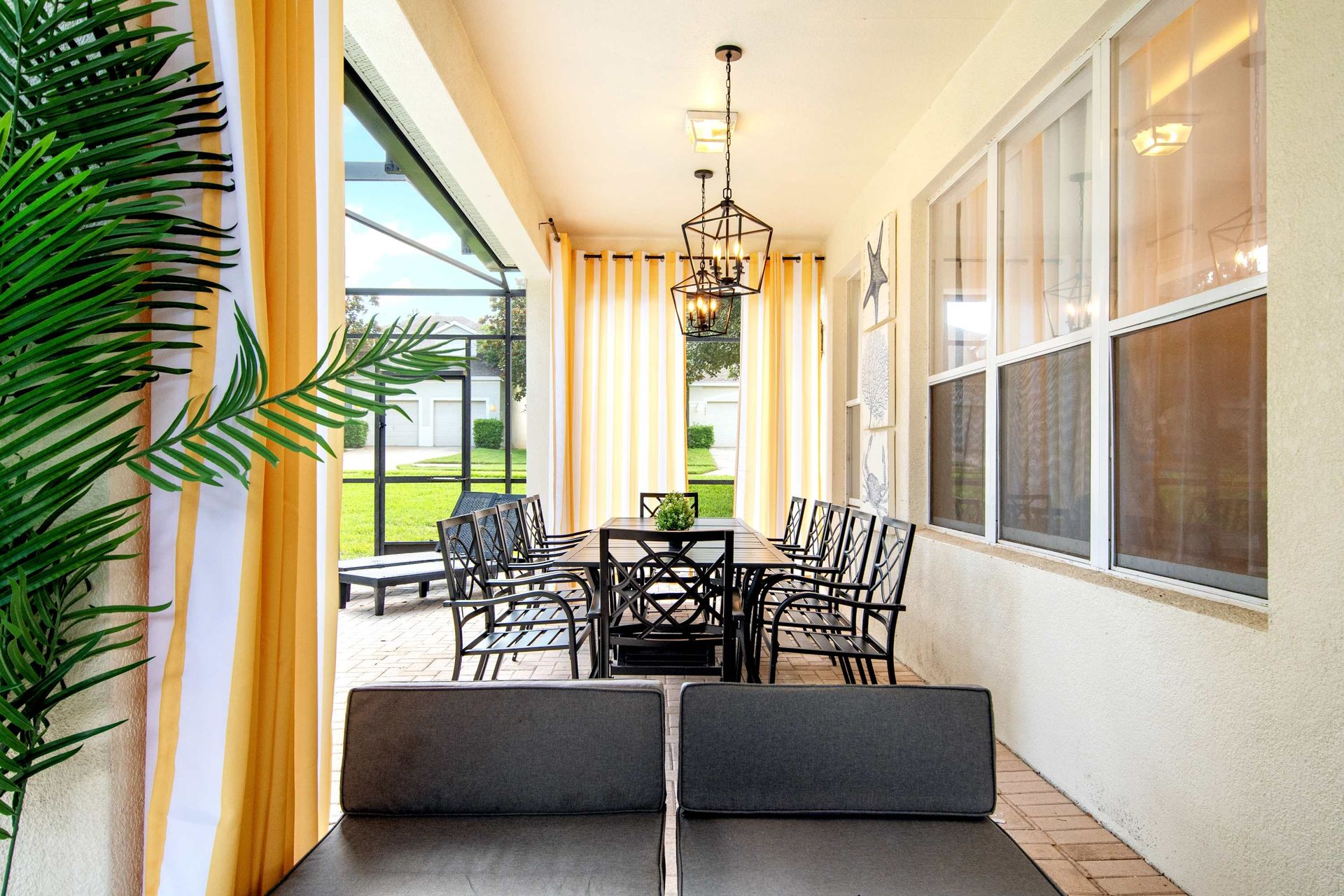 Covered outdoor living room flows perfectly to the sunny, screened pool.