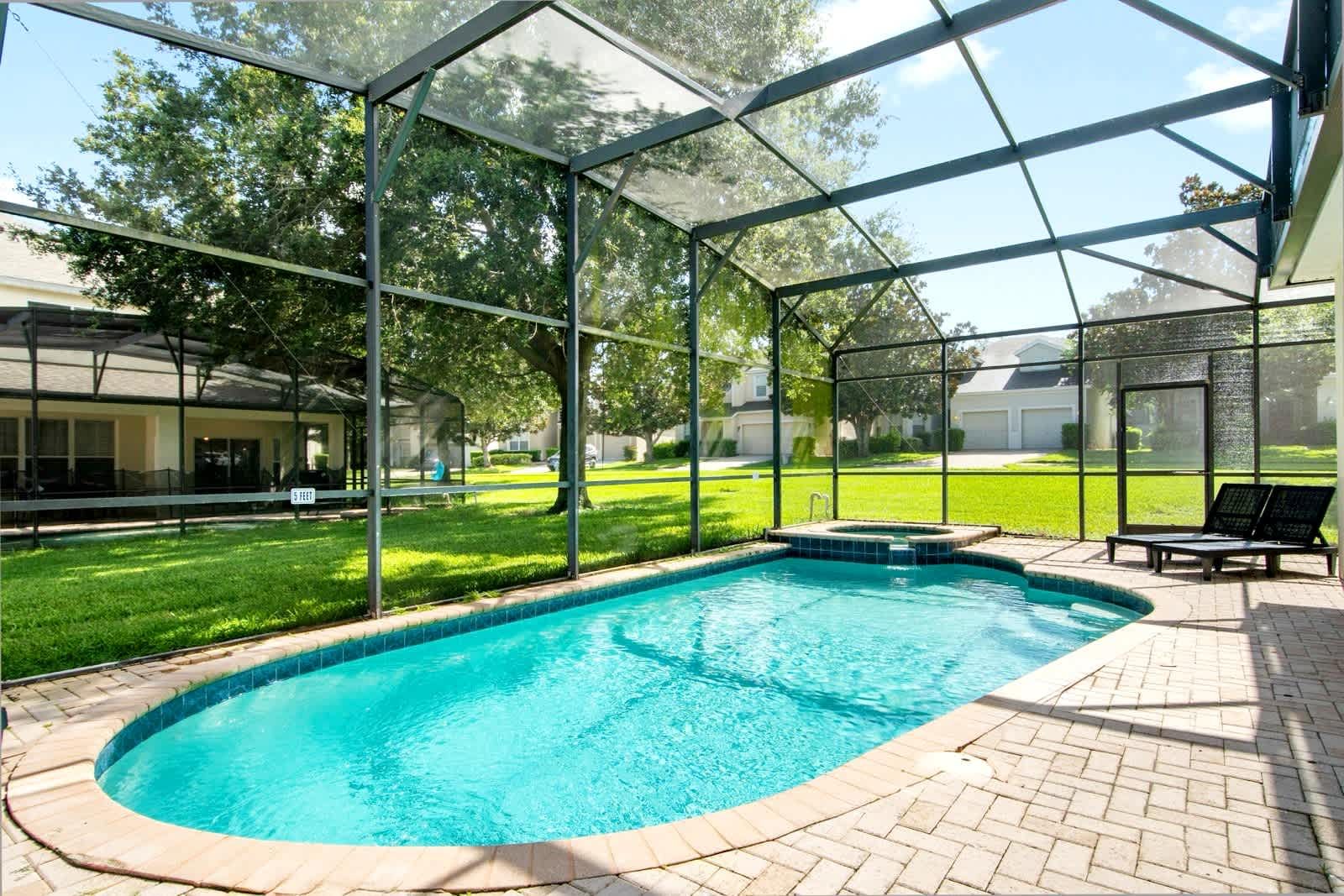 Sunlit, screened pool area with spa and outdoor seating.