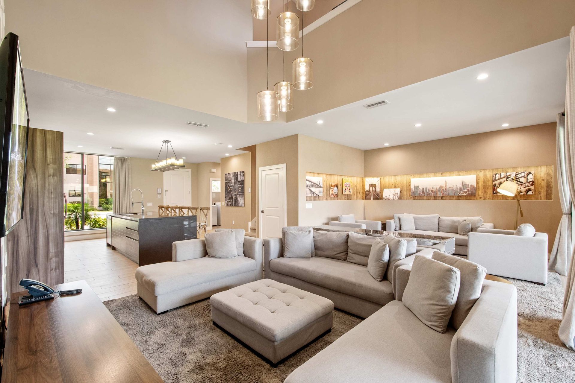 Grand living room with vaulted ceiling, plush sectional, and gallery lighting.