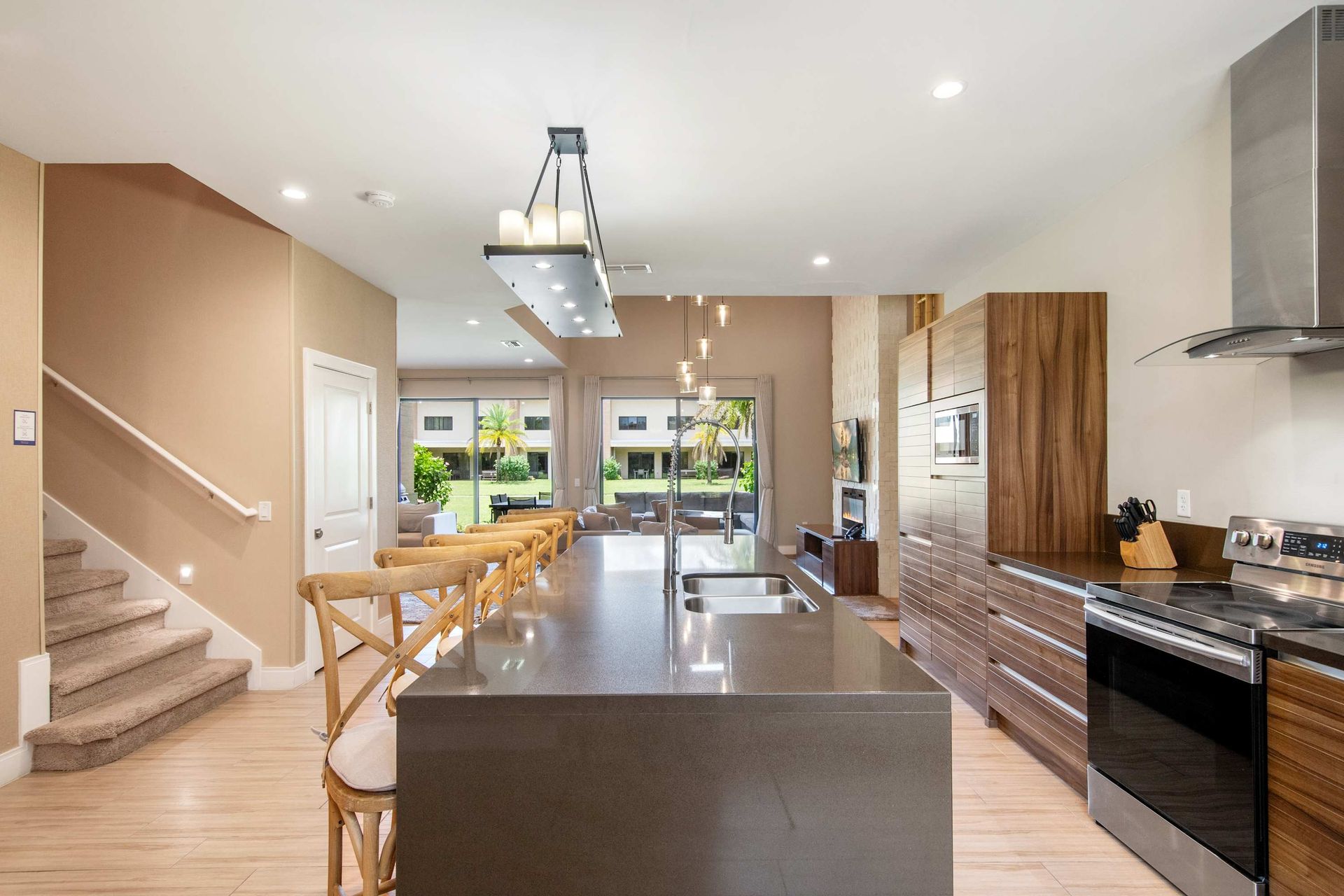 Oversized island and gourmet kitchen flow to the sunlit living area.