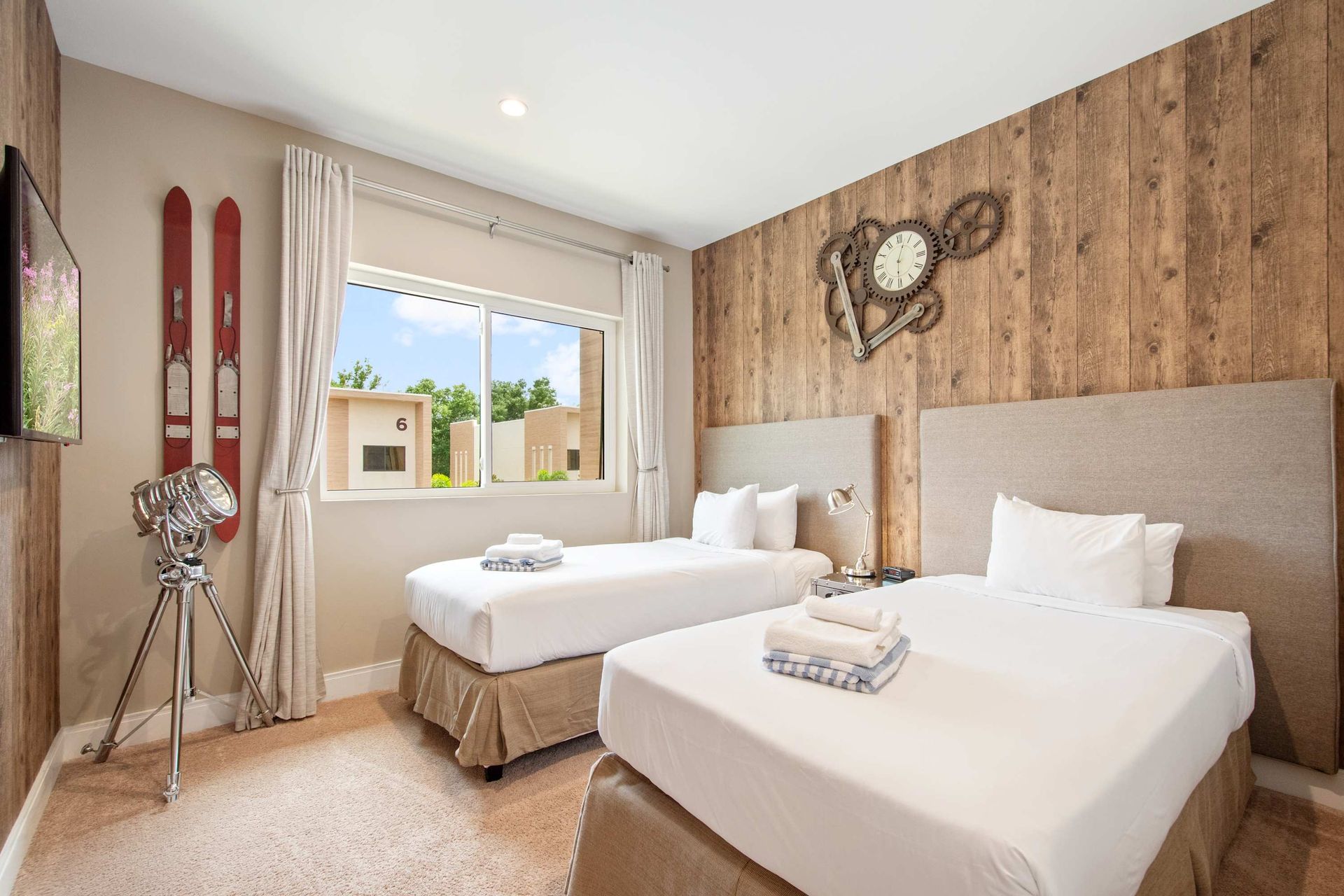 Cozy ski lodge theme: twin beds, wood wall, and vintage ski decor.