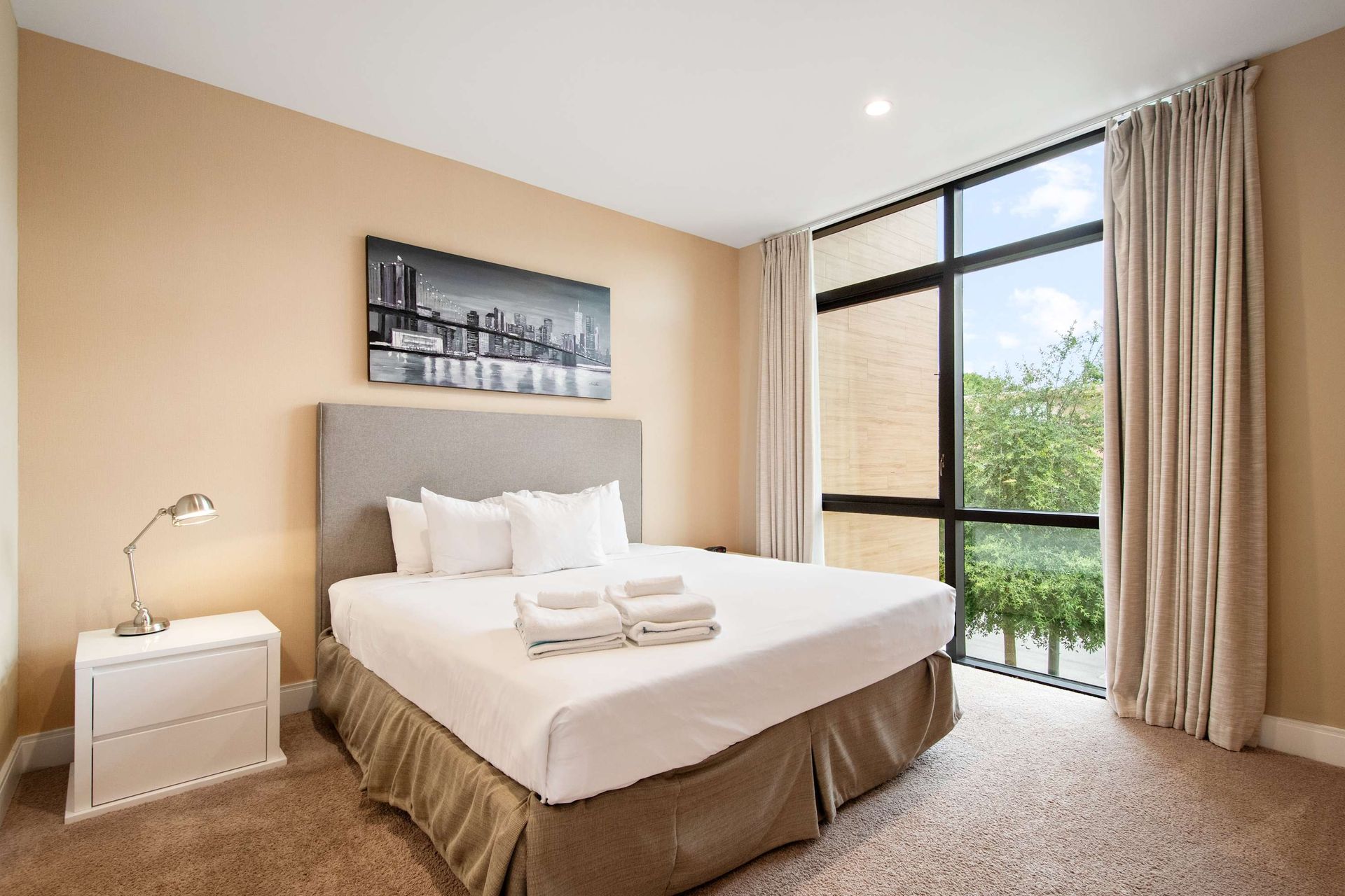 Cozy comfort and a bright window view in this modern Queen room.