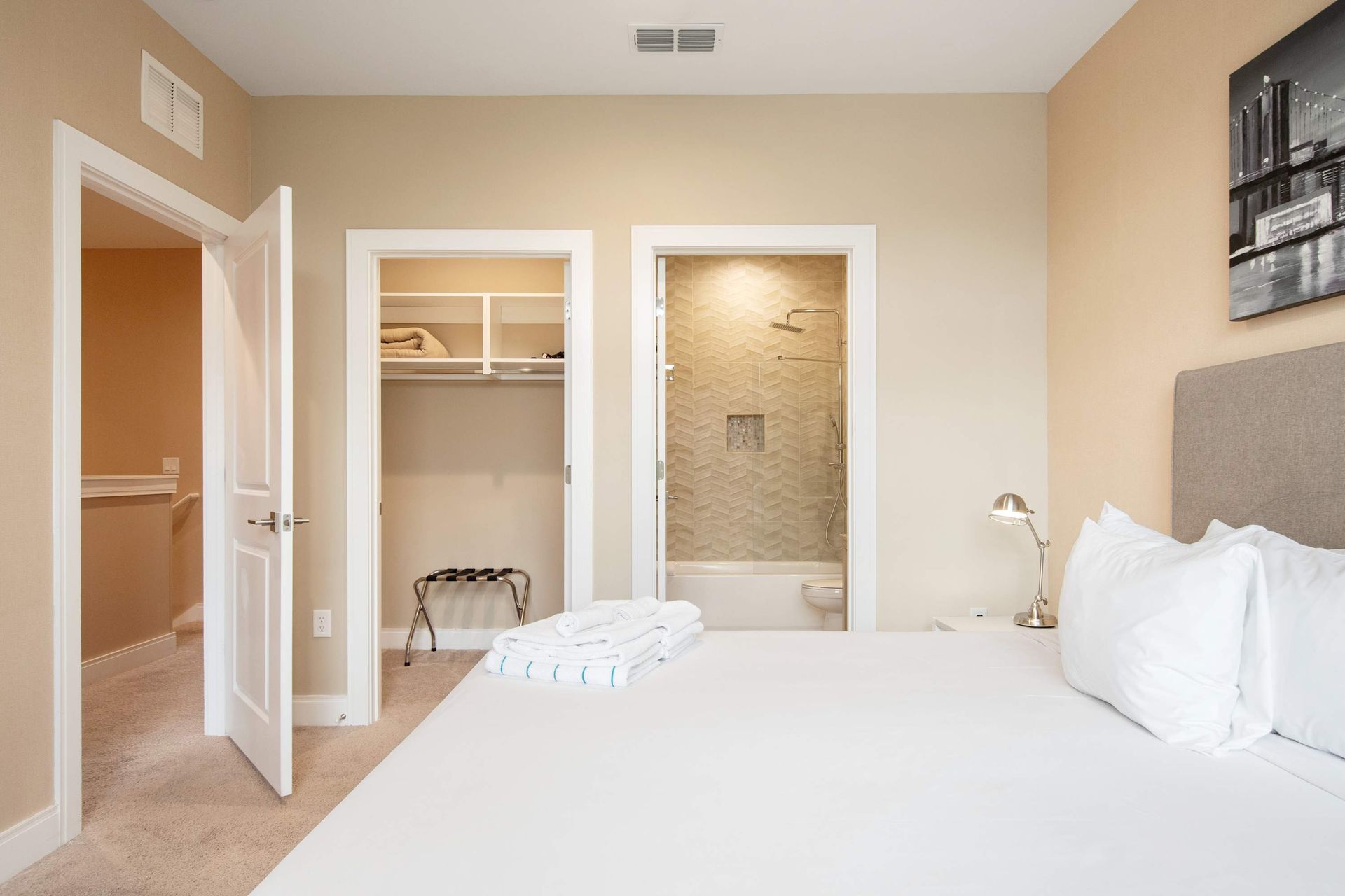 Queen bed with walk-in closet, luggage rack, and en suite bath access.