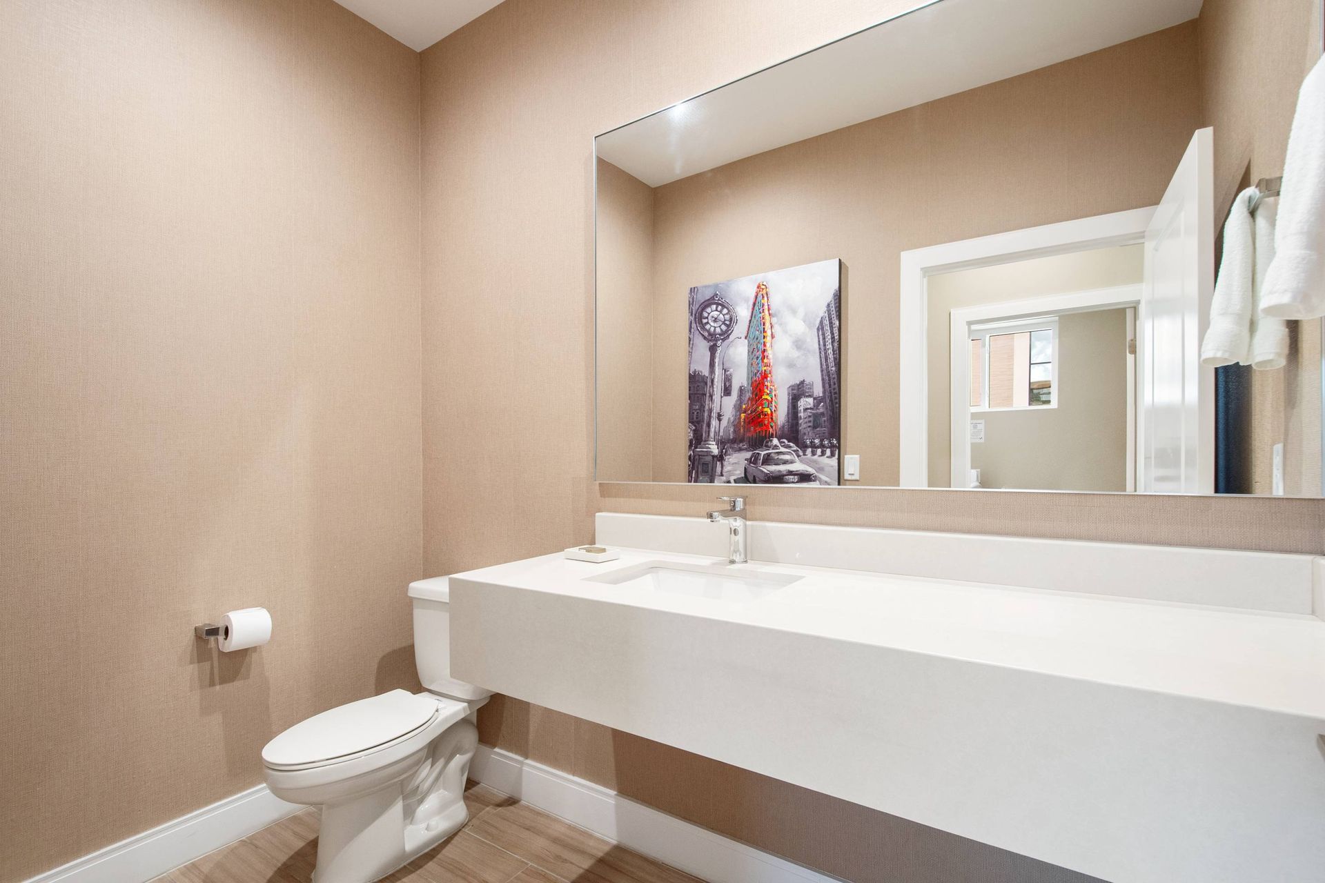 Sleek floating vanity and large mirror in a modern half bath.