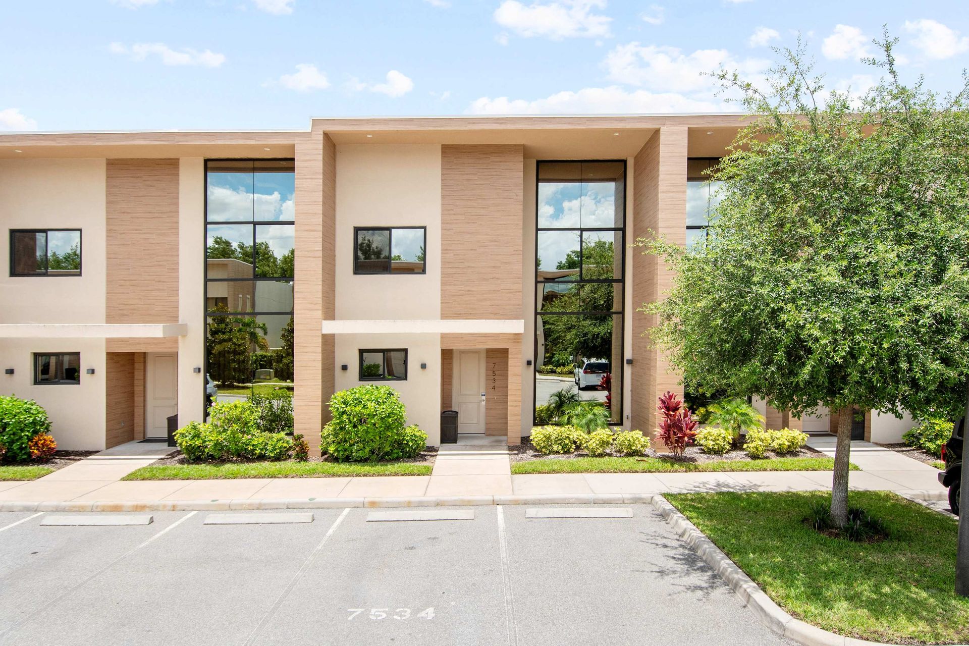 Sleek, modern townhomes with towering glass windows and sunny views.