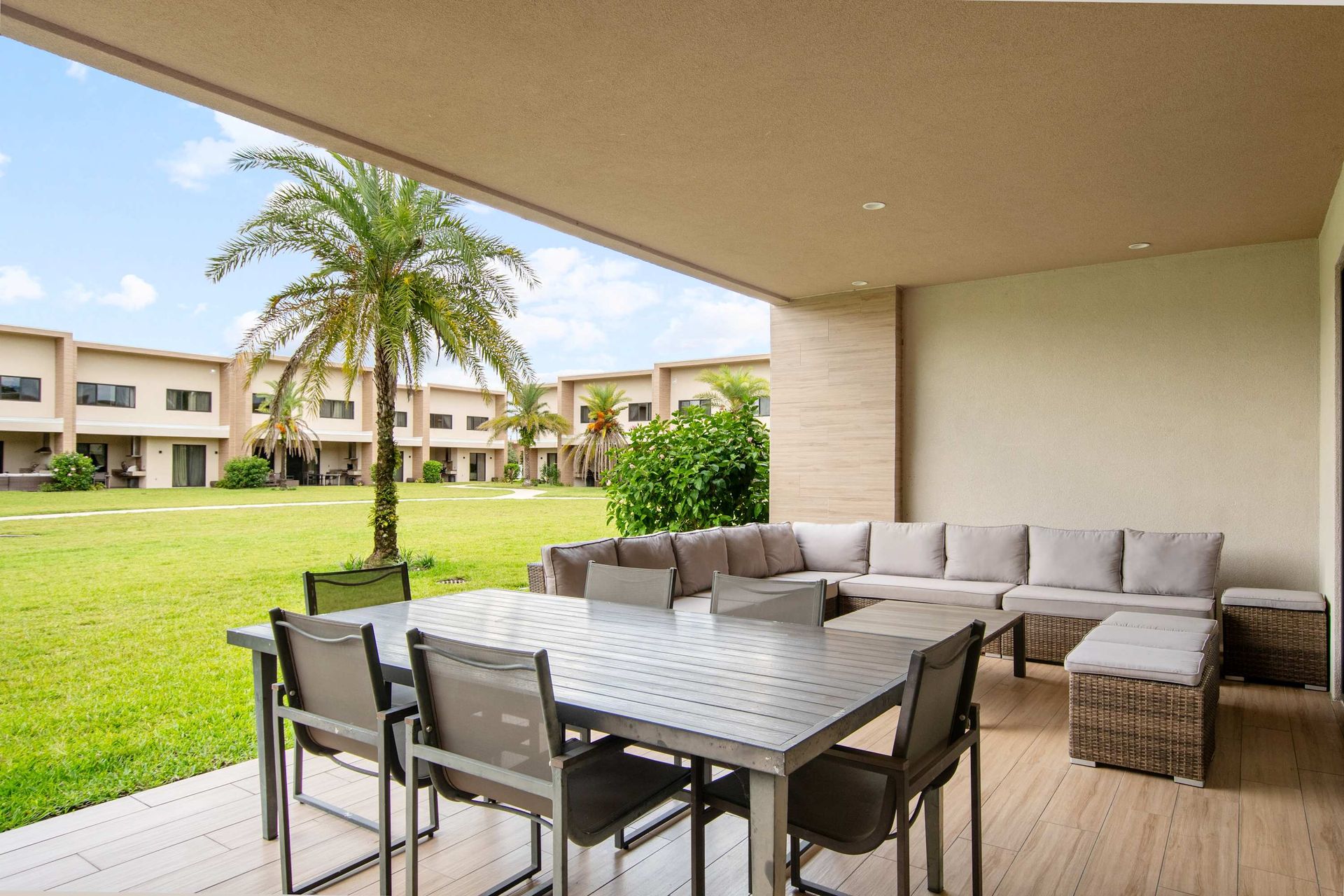 Covered patio with large dining table and plush sectional seating.