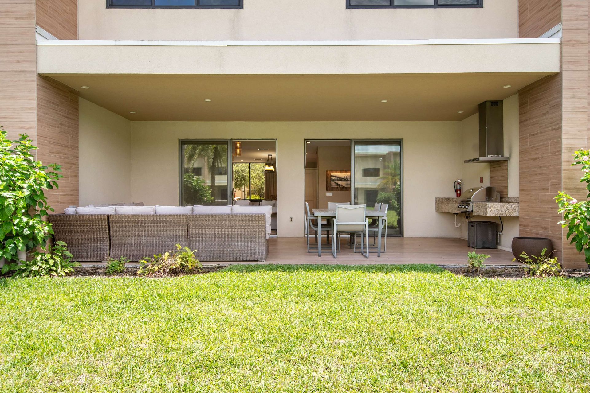 Covered patio with outdoor kitchen, dining, and sectional lounge area.