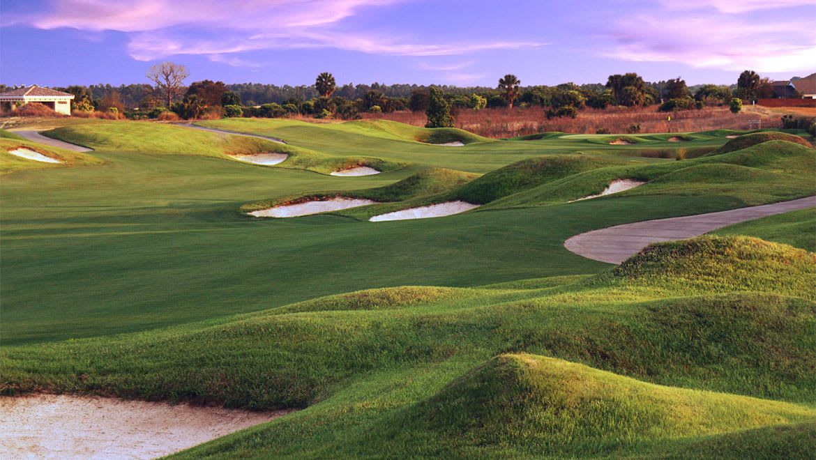 Rolling green fairways, bright bunkers, and a dramatic sunset sky.