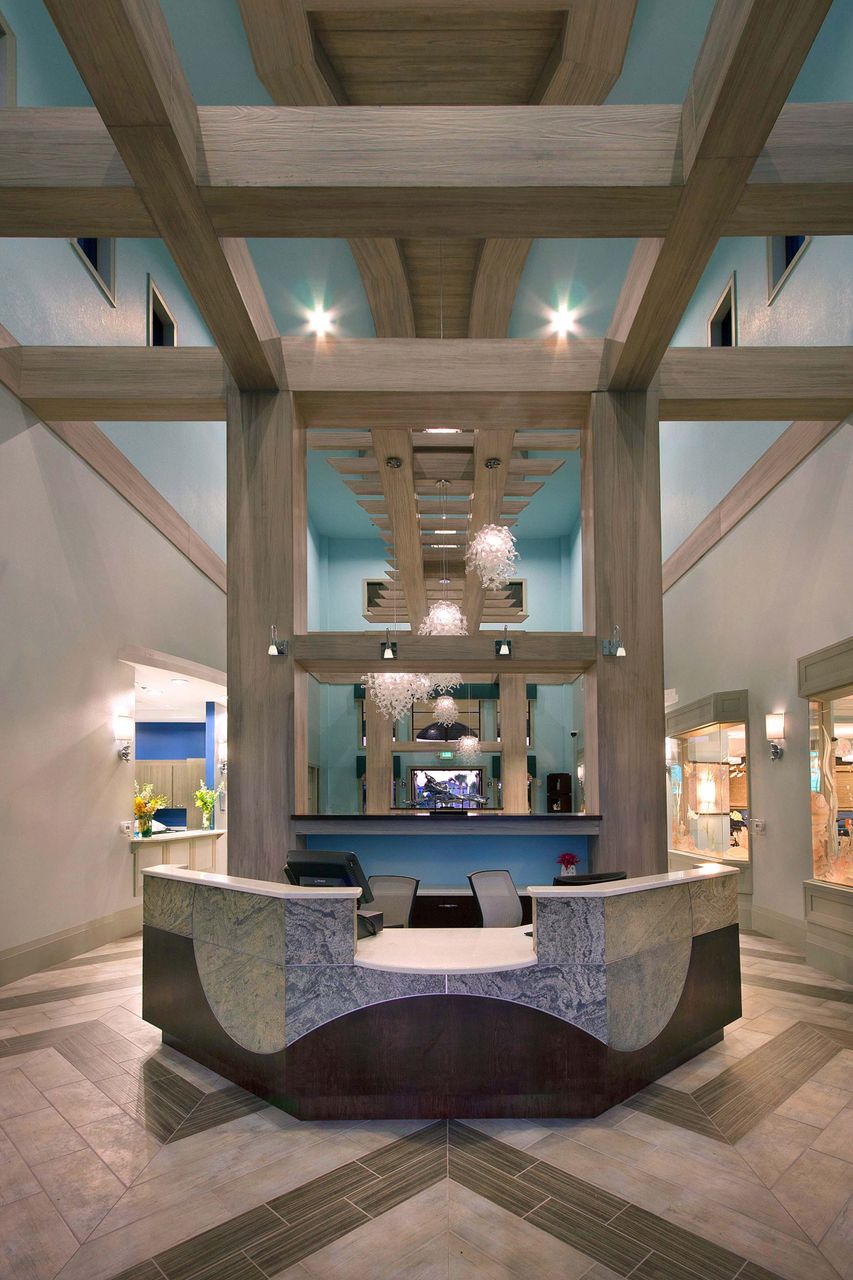 Grand resort lobby with striking wood beams and a sleek stone reception desk.