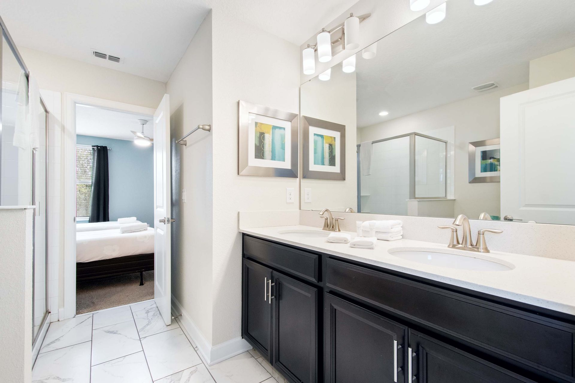 Master bath with dual vanity, dark cabinets, and direct bedroom access.