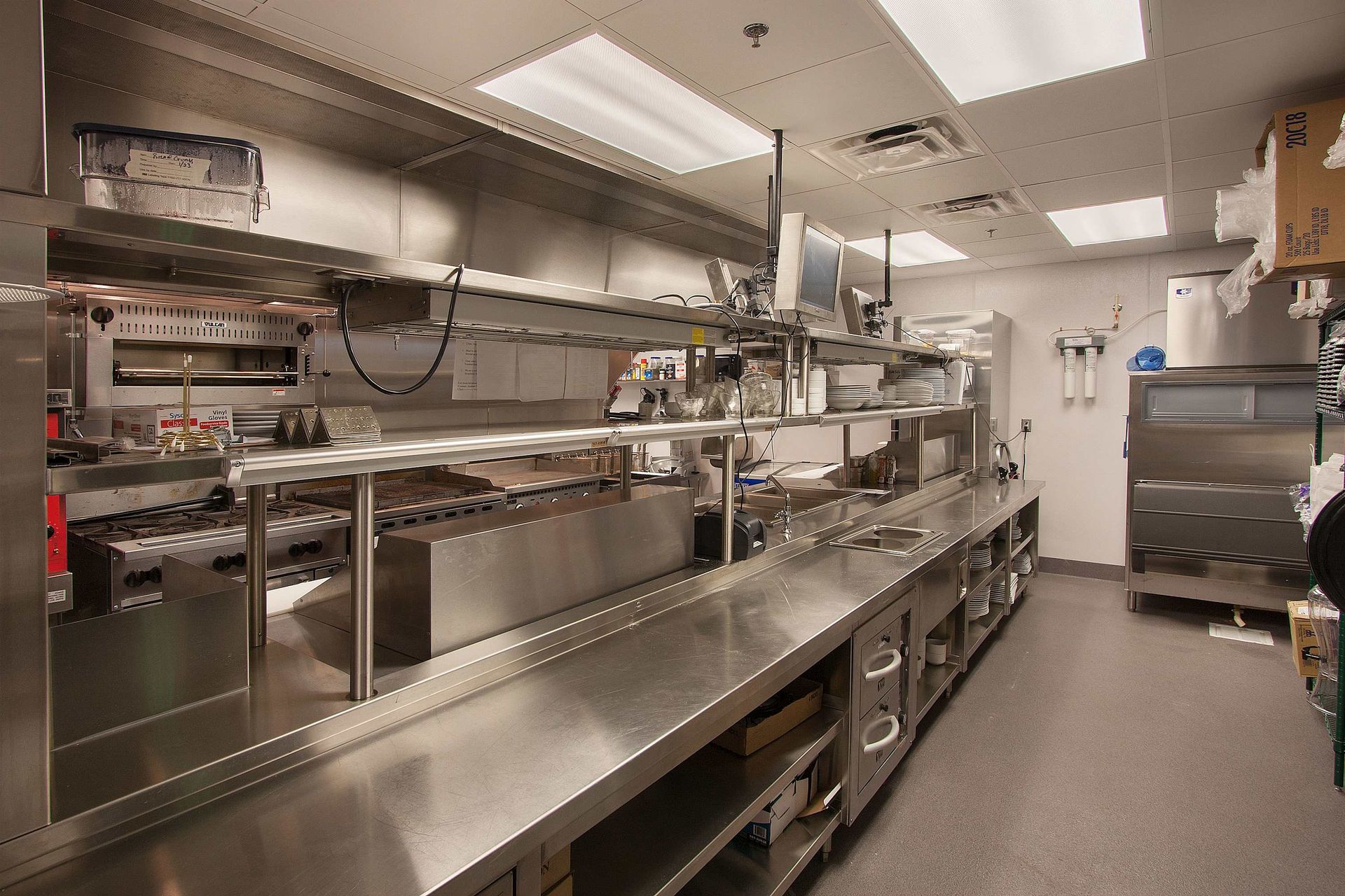 Sleek, bright, industrial kitchen dominated by metallic silver surfaces.