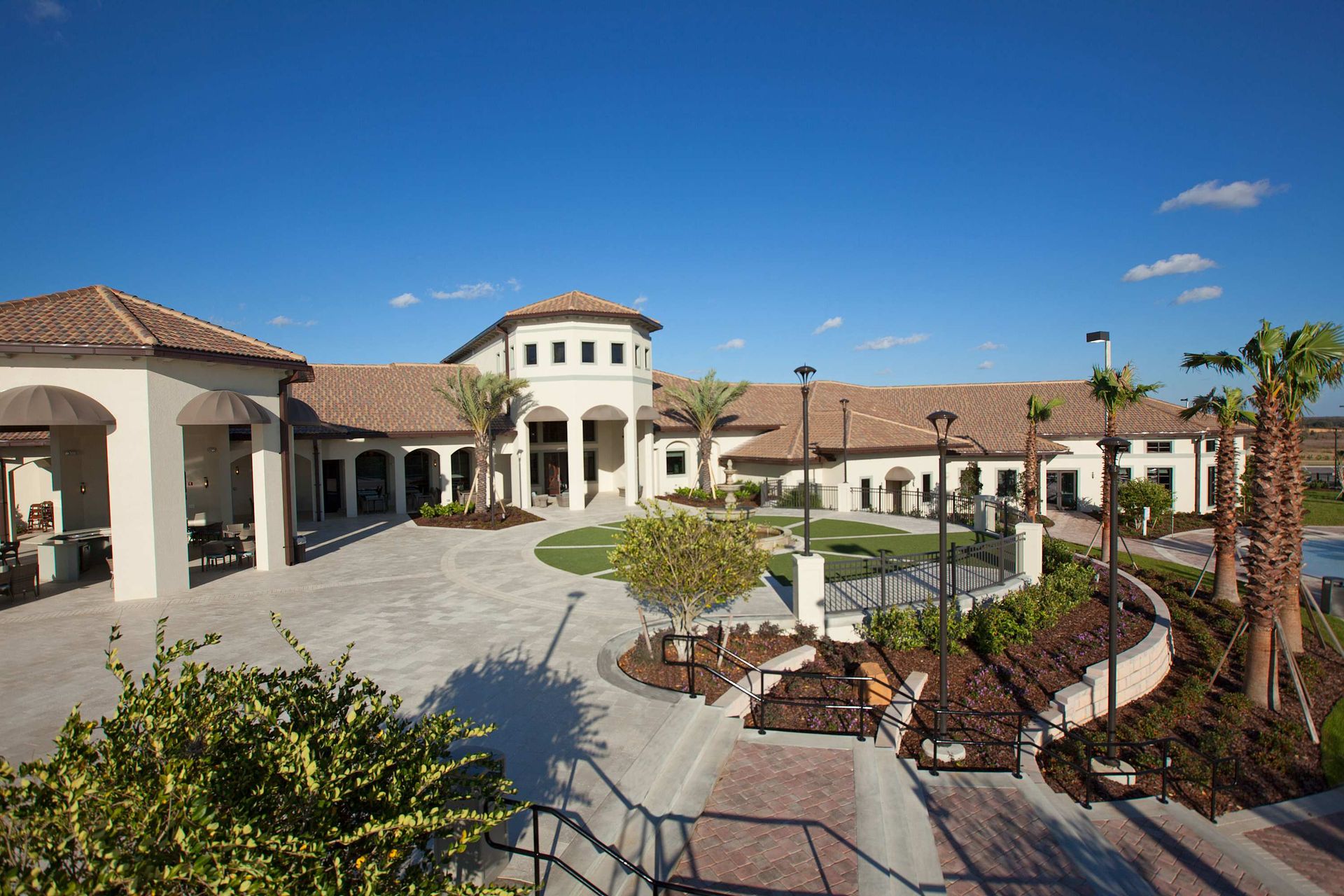 Resort clubhouse with a courtyard, turret, tile roof, and Mediterranean design.