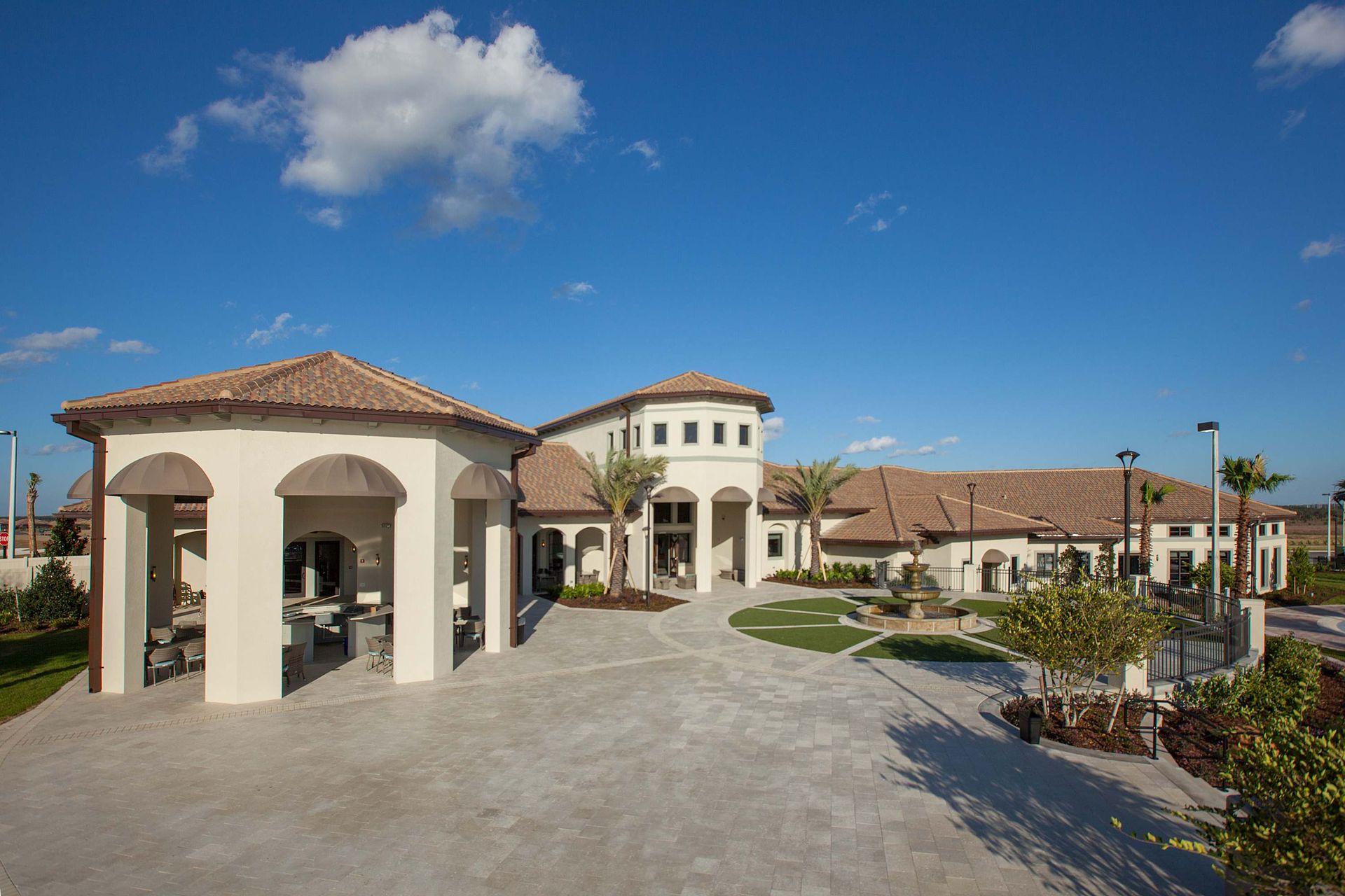 Resort clubhouse with a gazebo, turret, paved patio, and stucco walls.