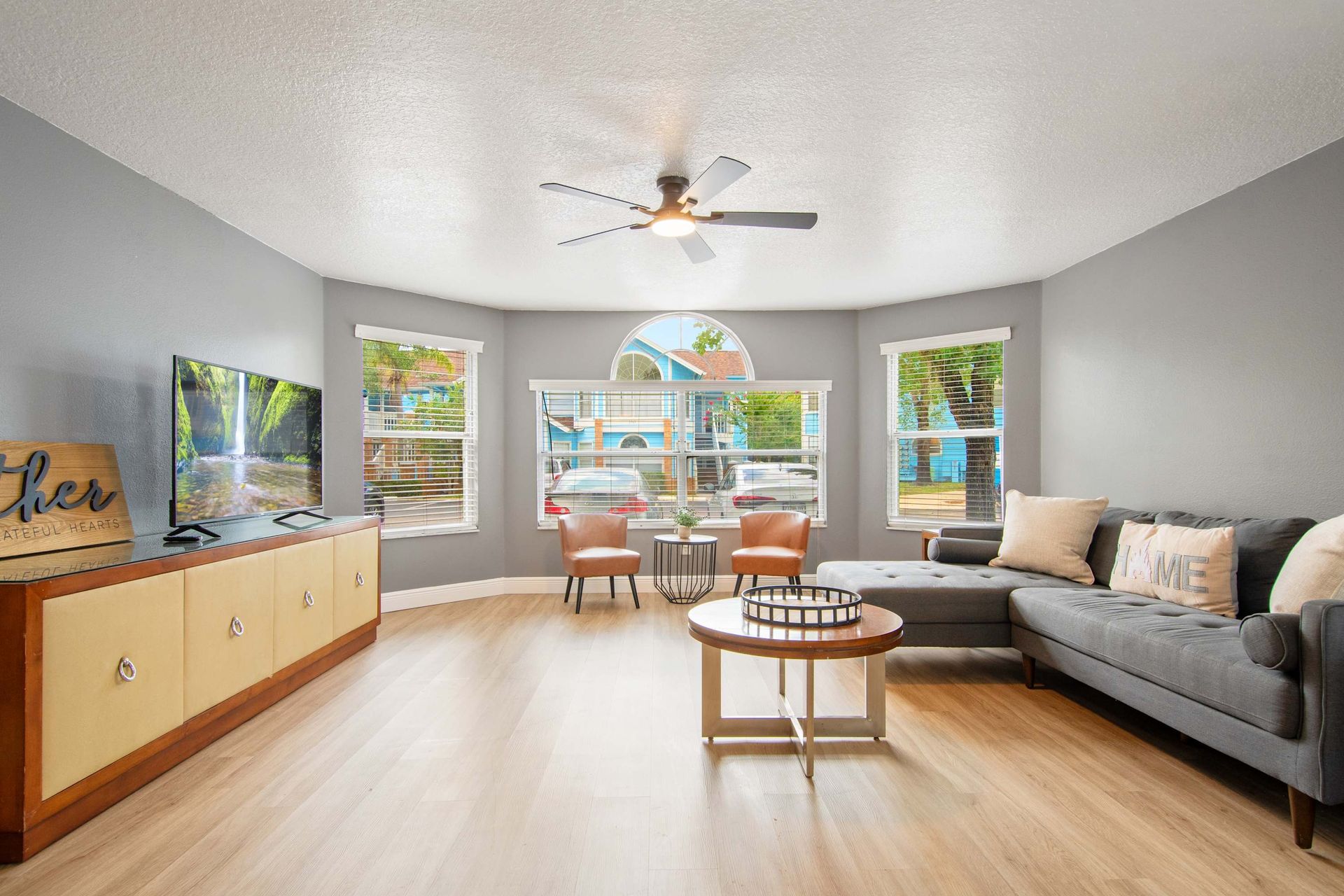Airy lounge with stylish sectional and unique window design.