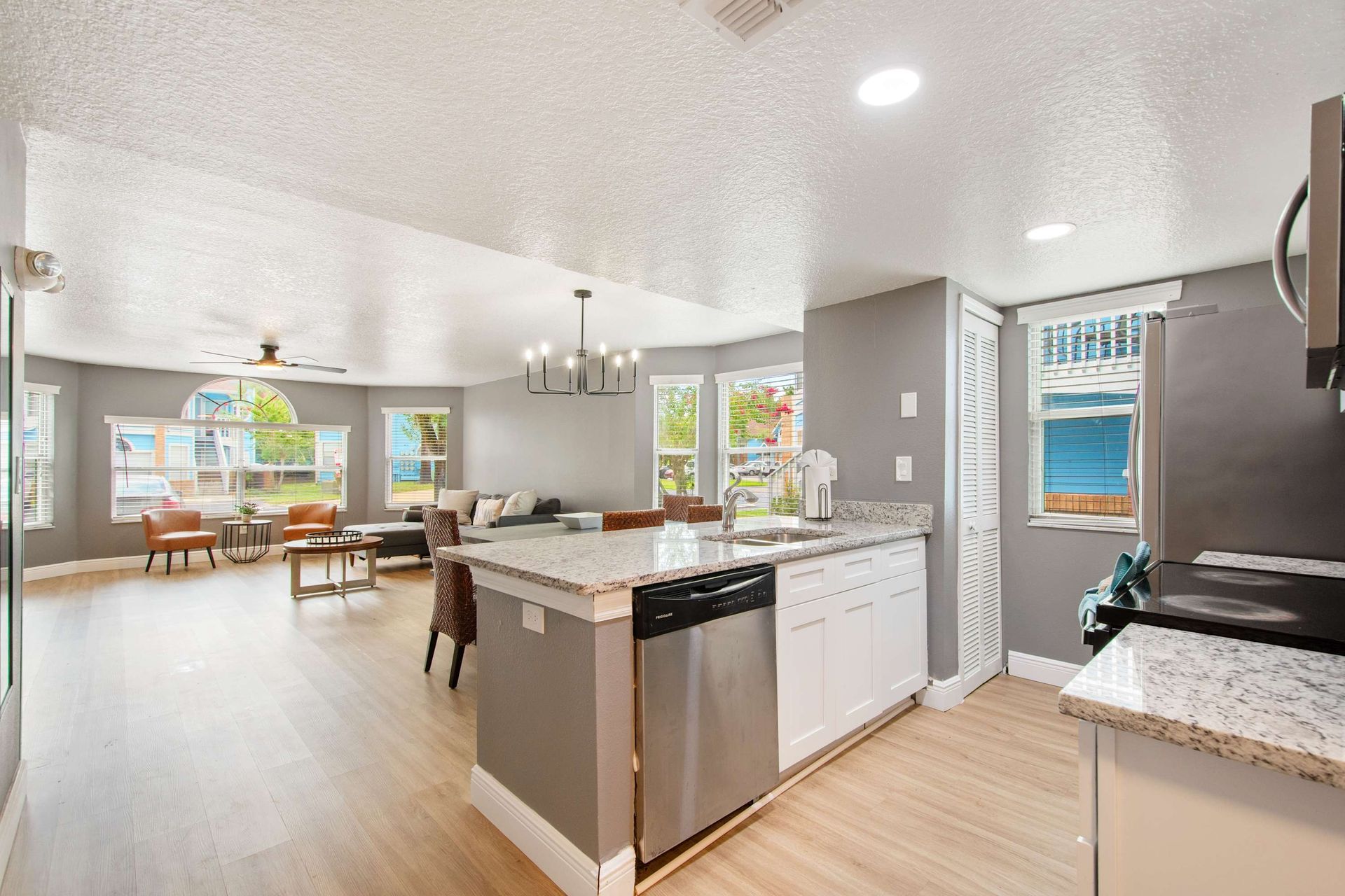 Open-concept kitchen with granite island flows to the bright living area.
