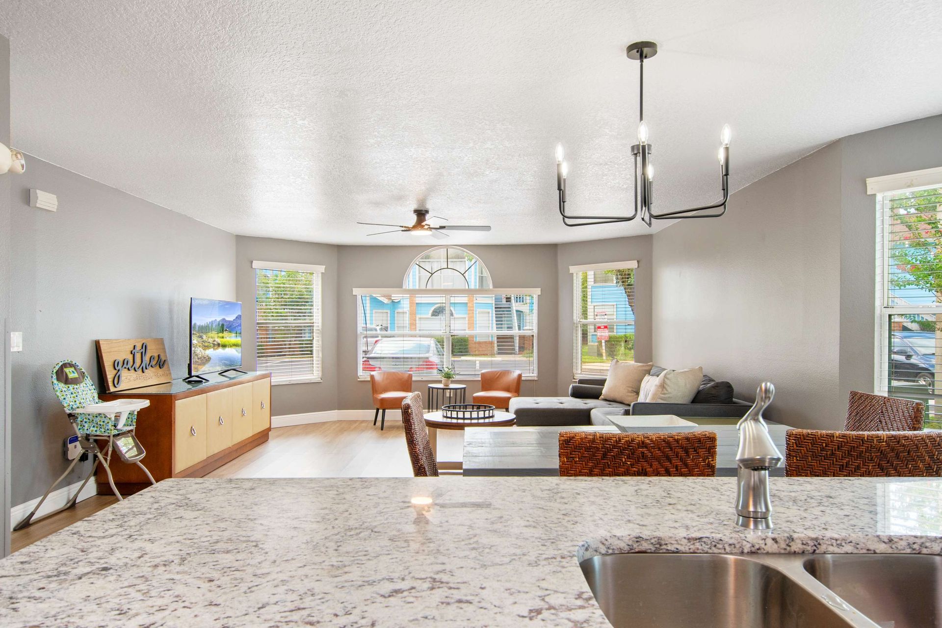 Modern lounge flooded with light, featuring granite counters and chic decor.