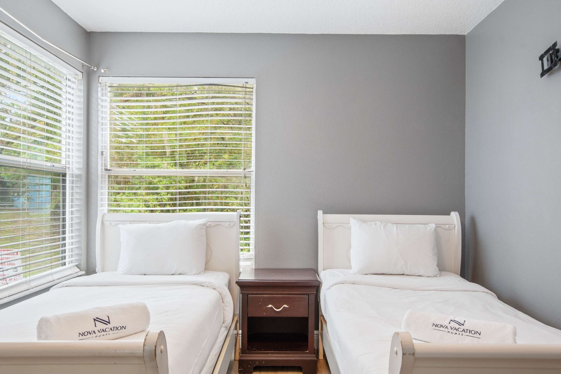 Twin bedroom with natural light and a peaceful gray palette. 
