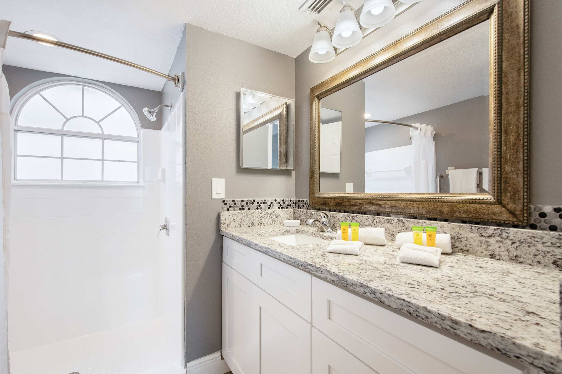 Sleek modern bath in gray and white with a spacious vanity. 