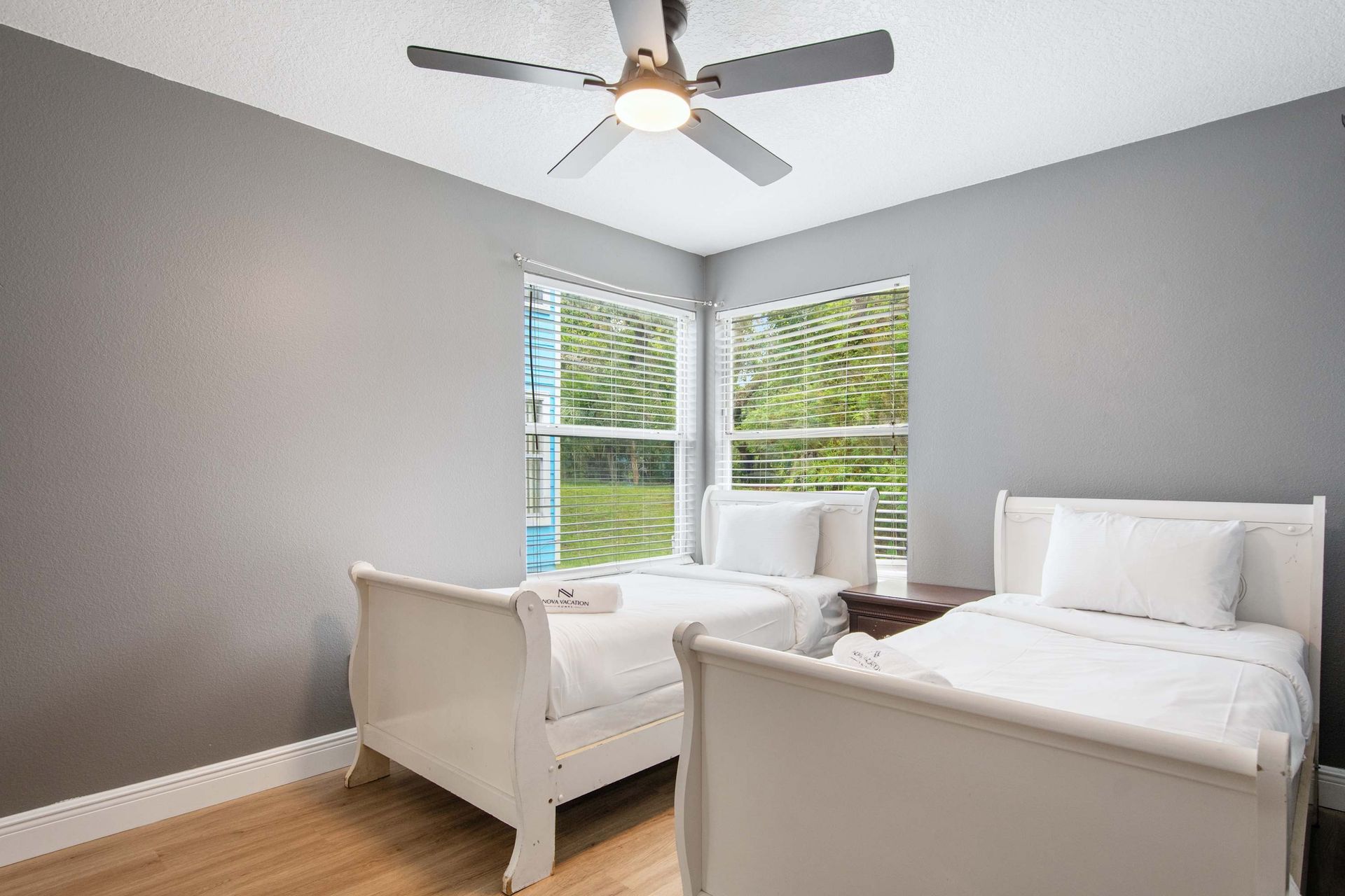 Bright, peaceful twin room with large windows and crisp white linens.