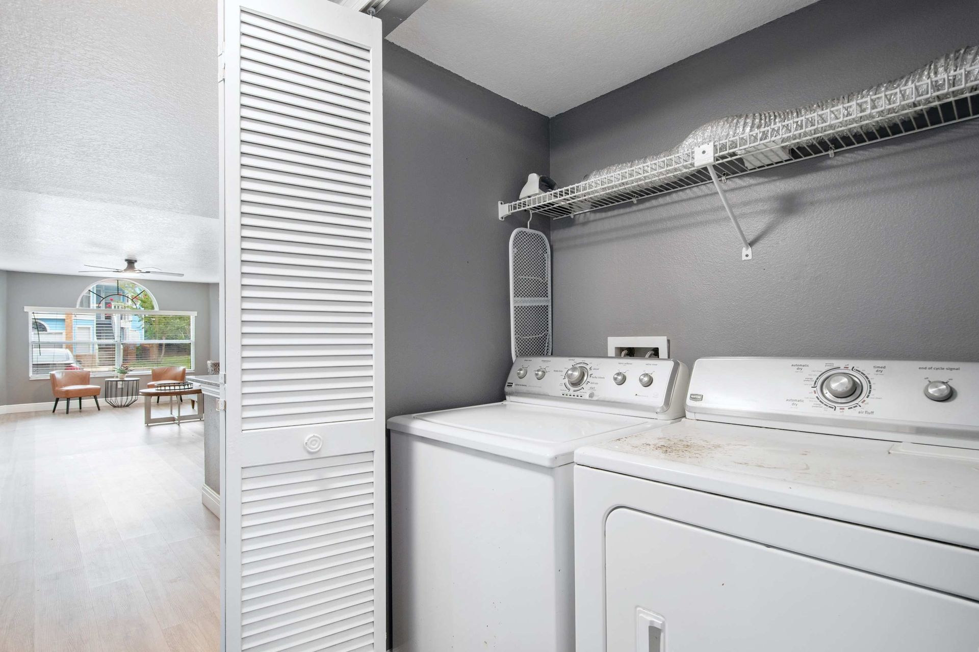 In-unit laundry: full-size washer and dryer with storage shelving. 
